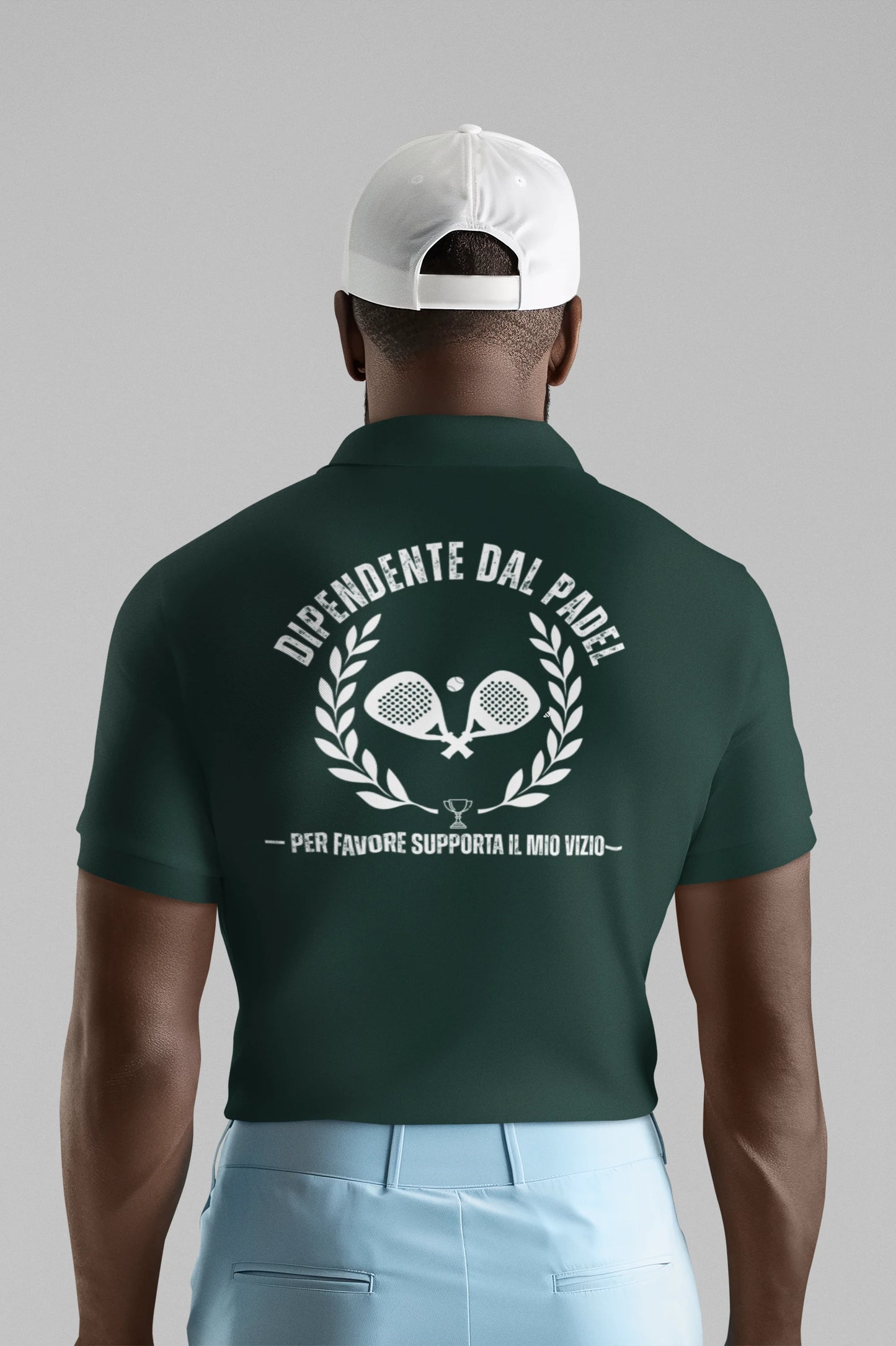 Man wearing a green polo shirt with text and tennis racket design on the back, against a gray background