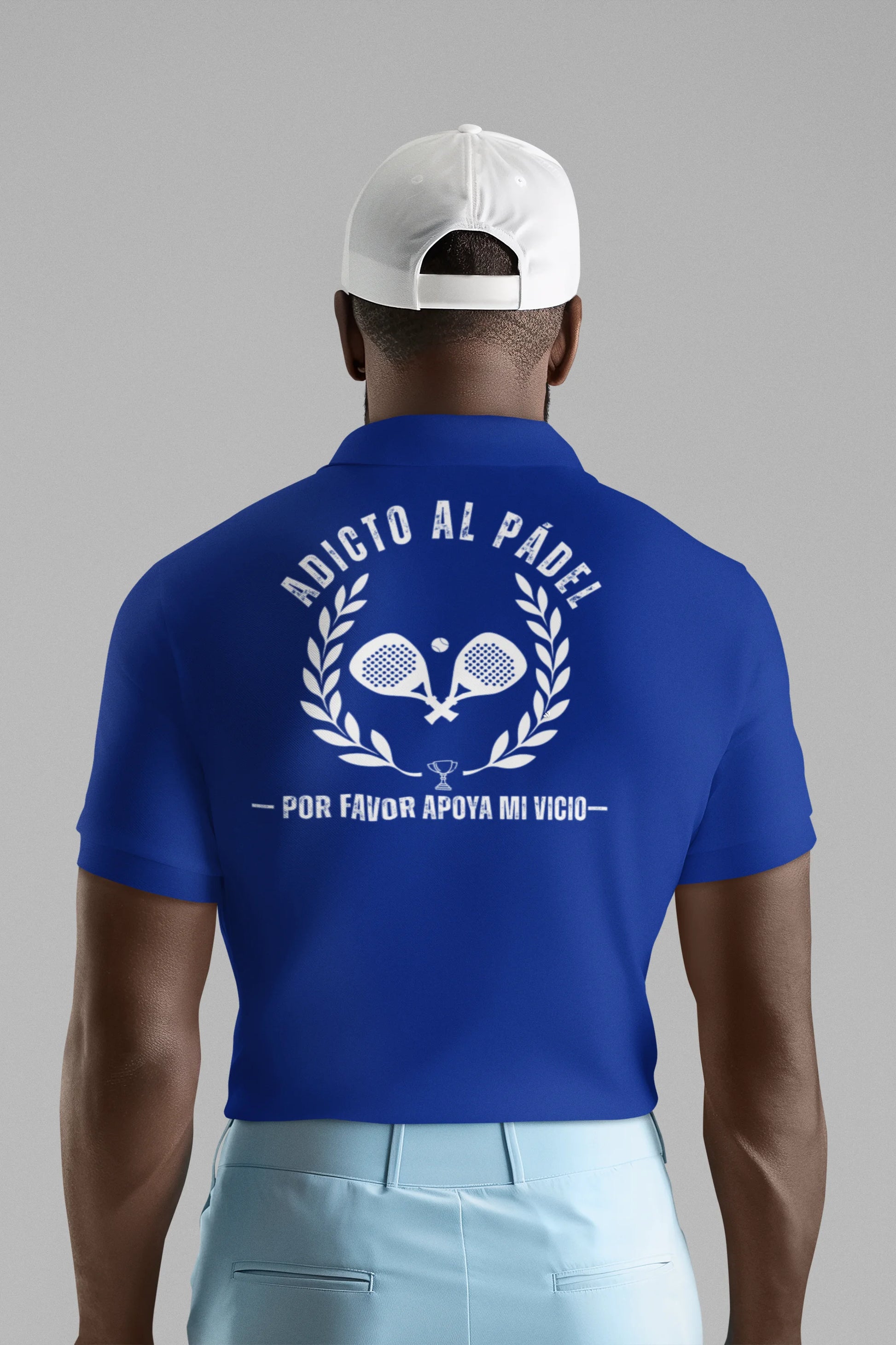Person wearing a blue polo shirt with text and graphics on the back, standing against a gray background.