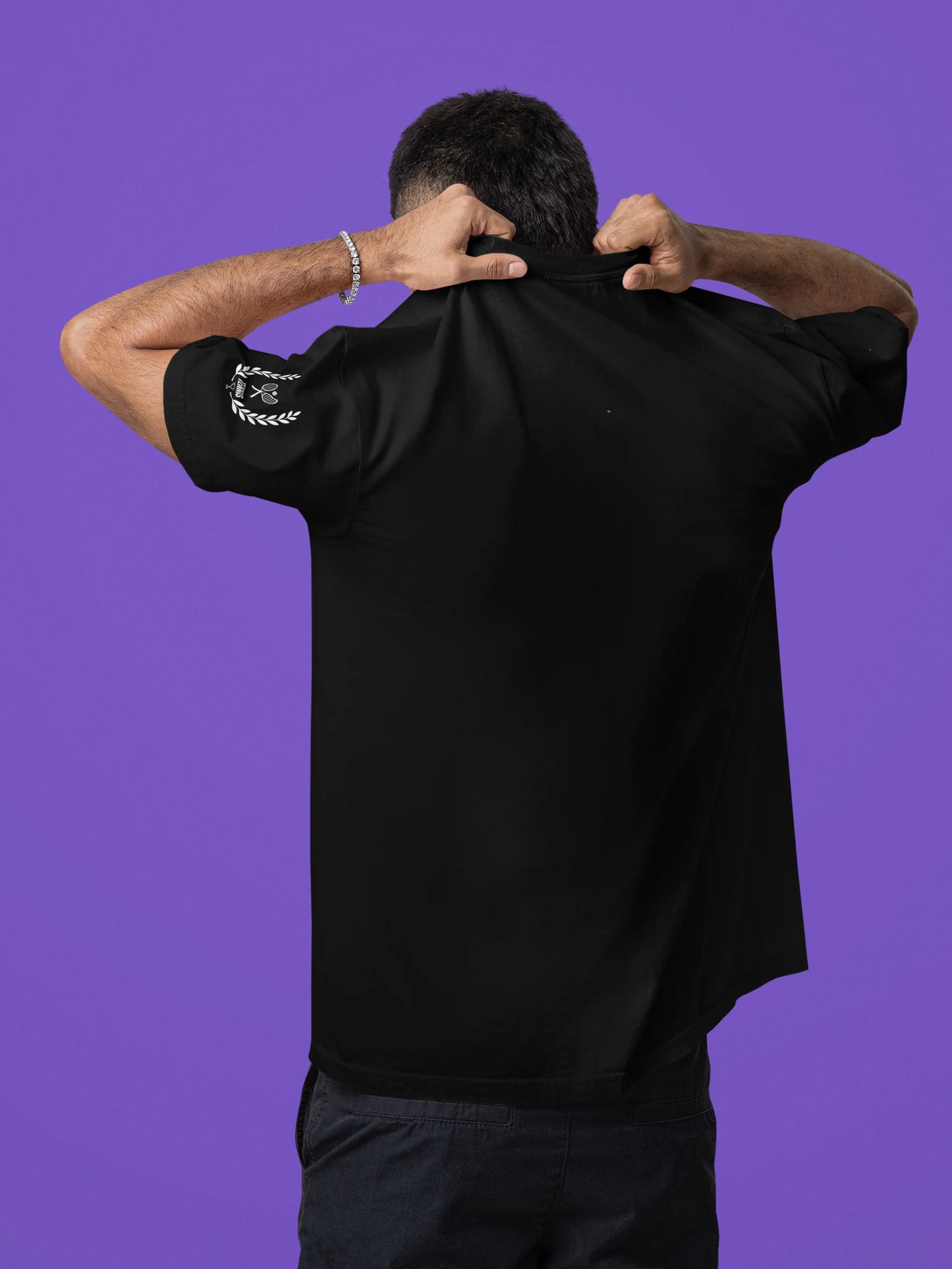 Person wearing a black shirt with text on the back against a purple background