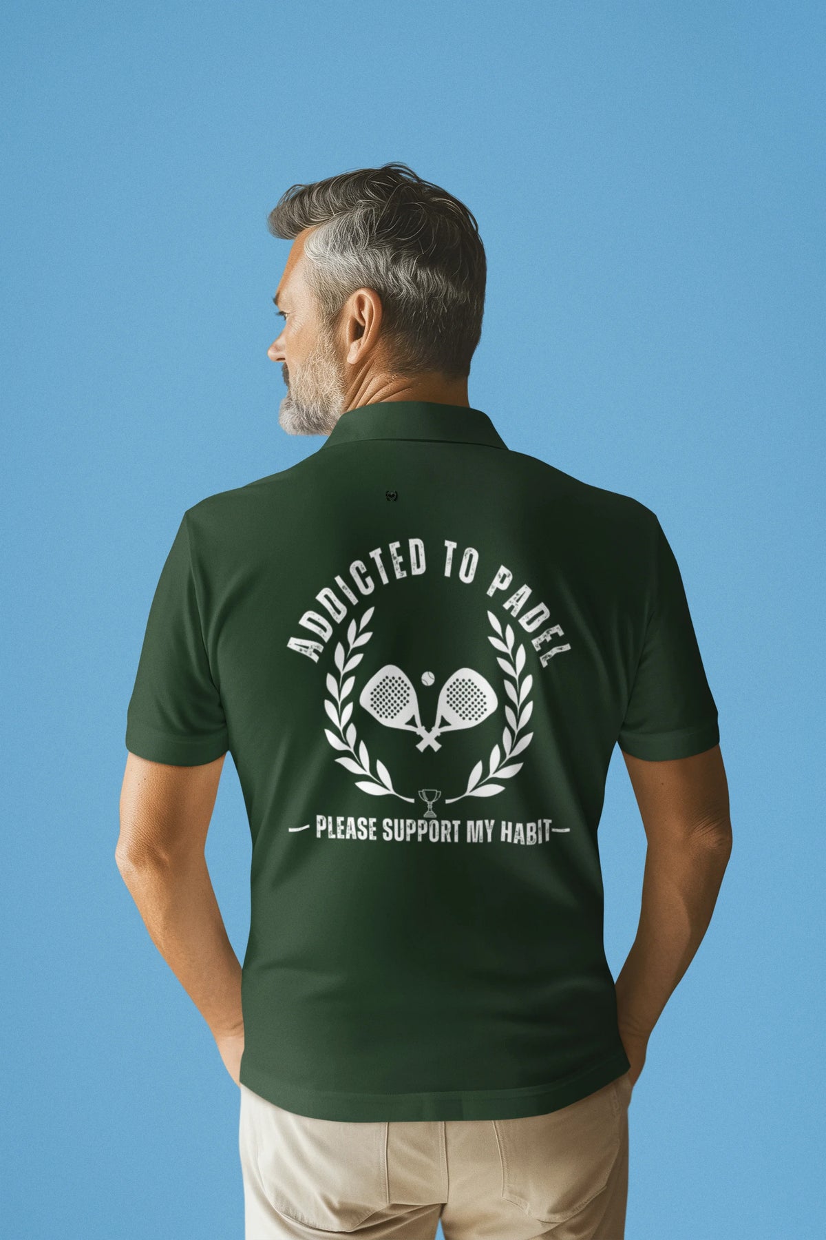 addicted to padel Man wearing a green polo shirt with text on the back against a blue background