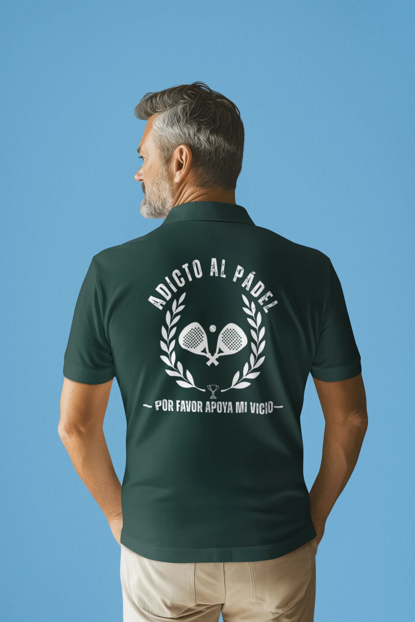 Man wearing a green polo shirt with a graphic design on the back against a blue background