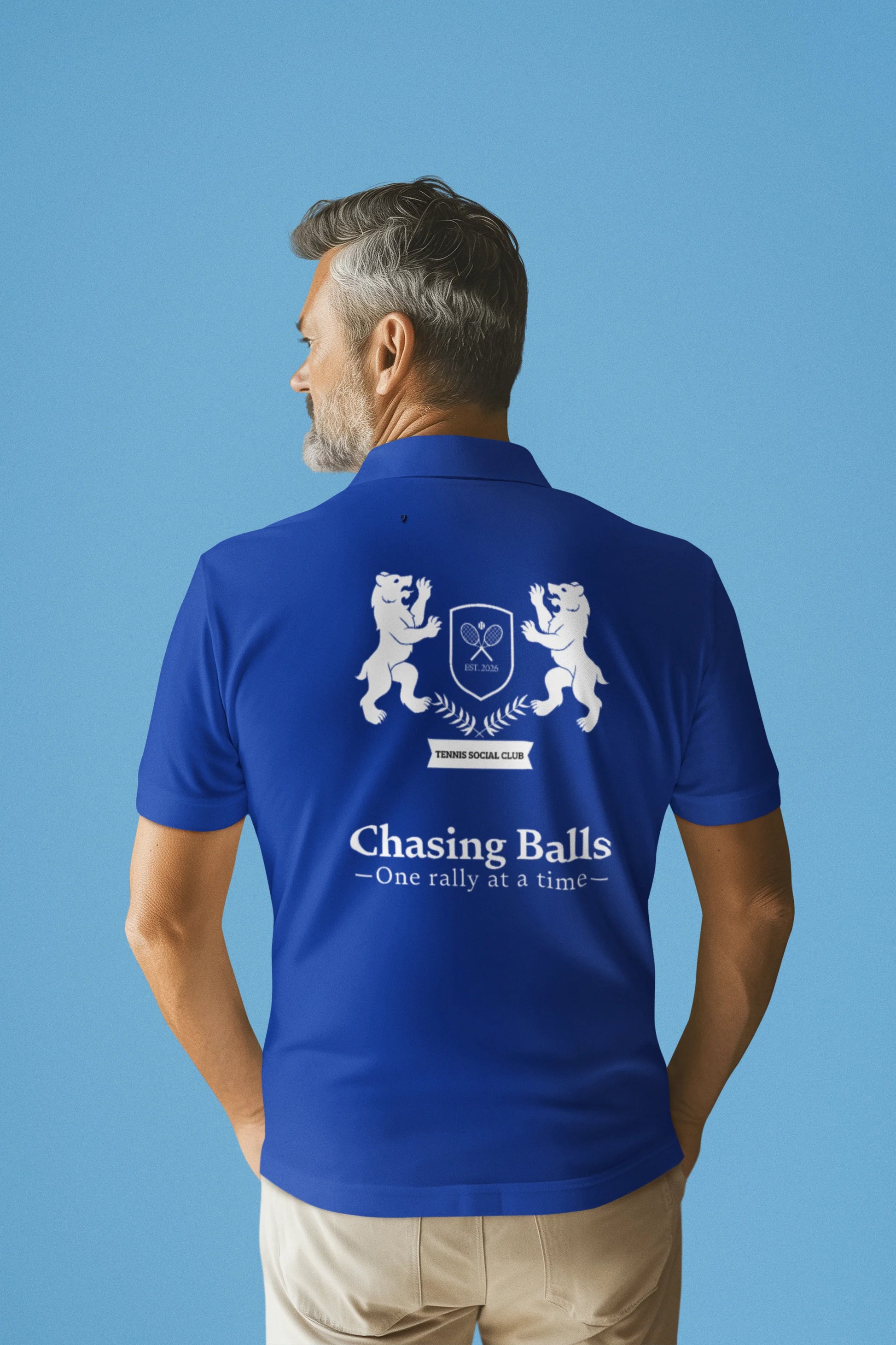 Man wearing a blue polo shirt with a logo and text on the back against a blue background