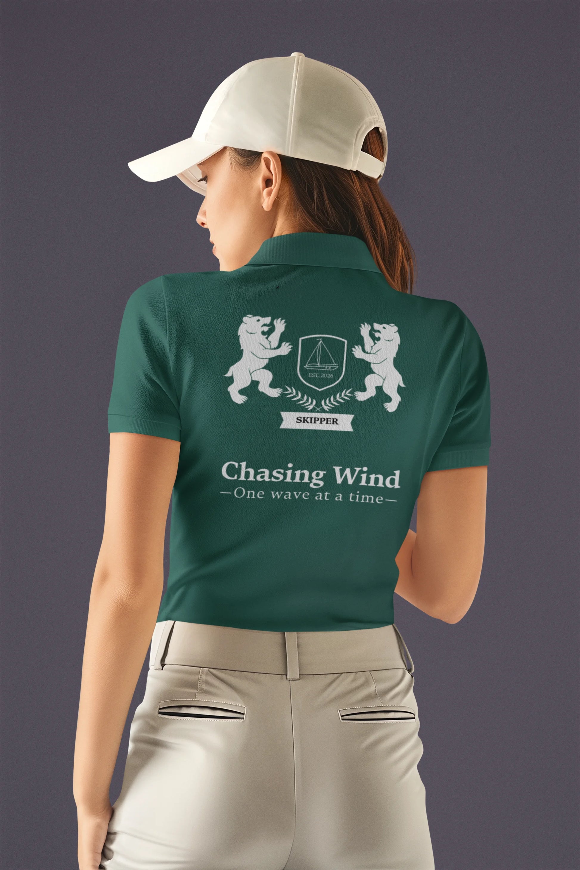 Sailing Polo Shirt Person wearing a green polo shirt with a logo and text on the back, against a dark background