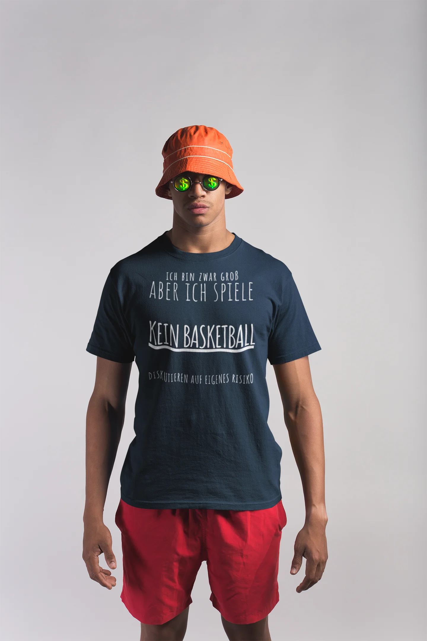 Person wearing a navy t-shirt with text, red shorts, and an orange bucket hat on a light gray background