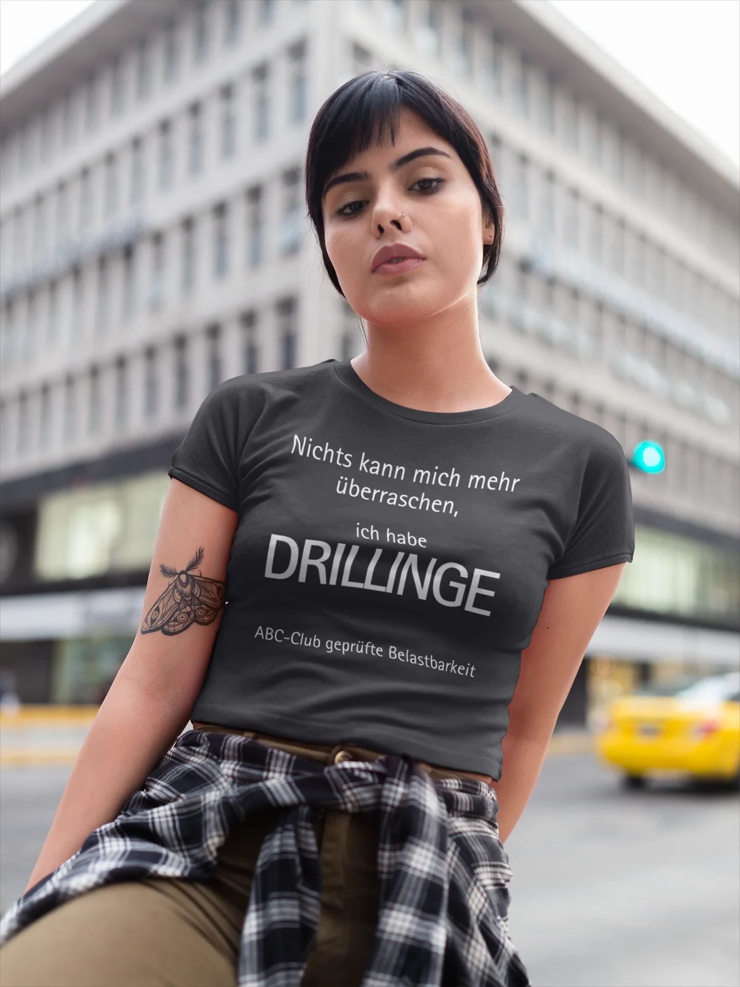 Geschenk für Drillinge Woman wearing a t-shirt with German text in an urban setting