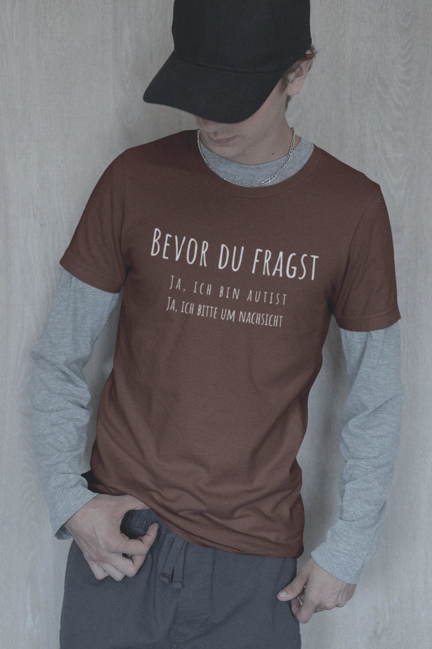 Person wearing a brown t-shirt with German text against a plain background