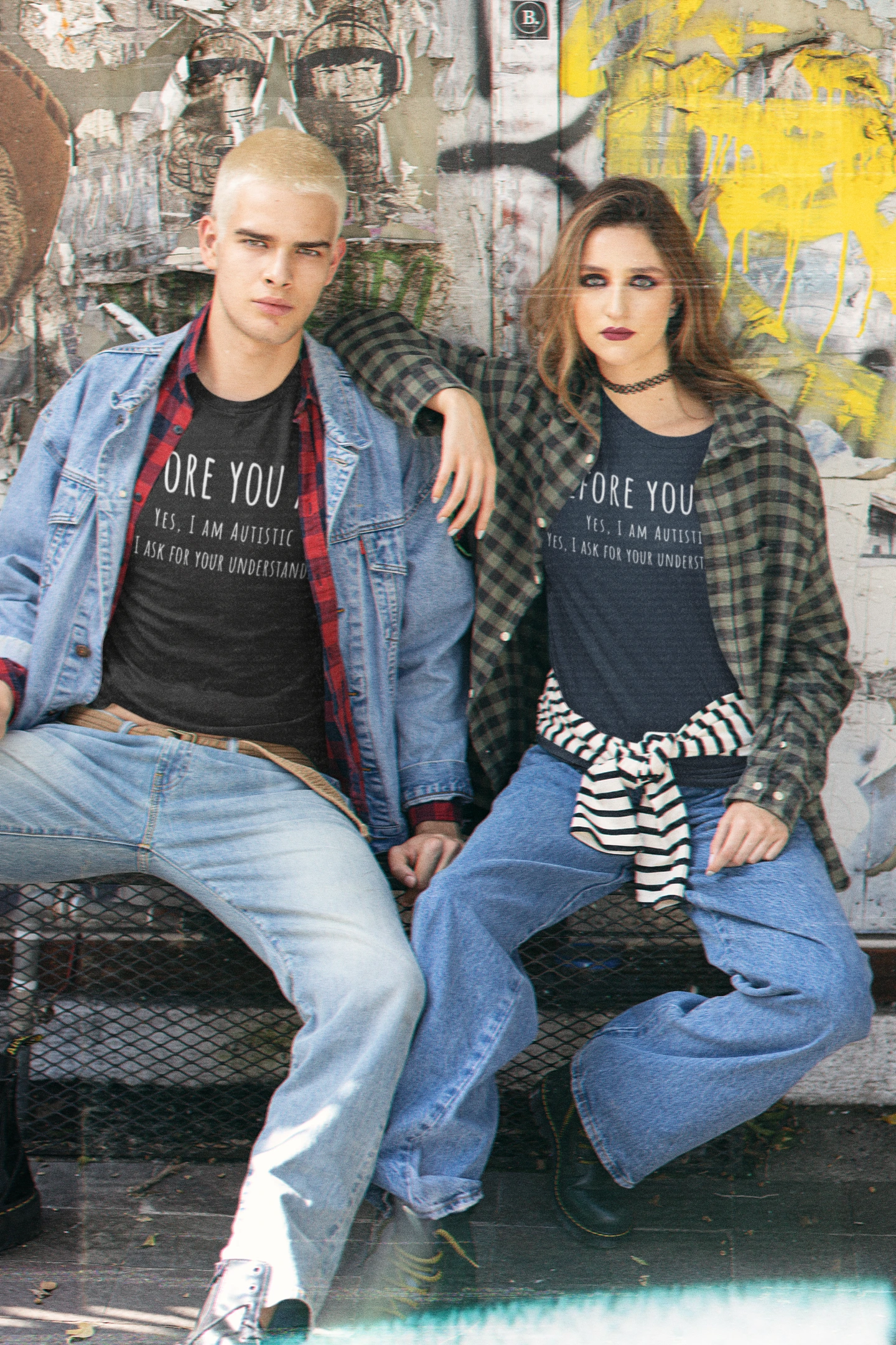 Two people sitting on a bench with a graffiti-covered wall in the background