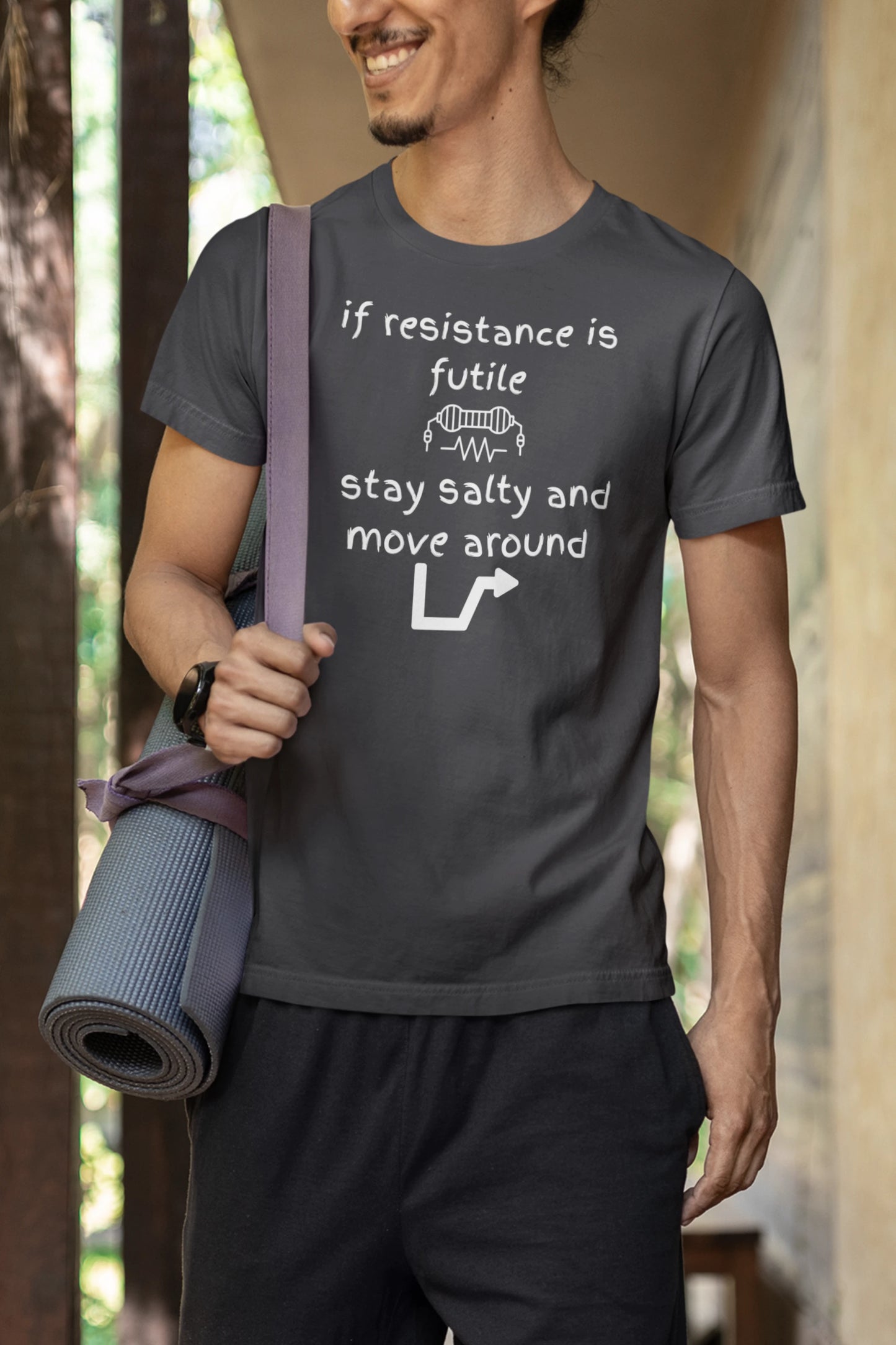 Person wearing a t-shirt with a humorous message, holding a yoga mat.