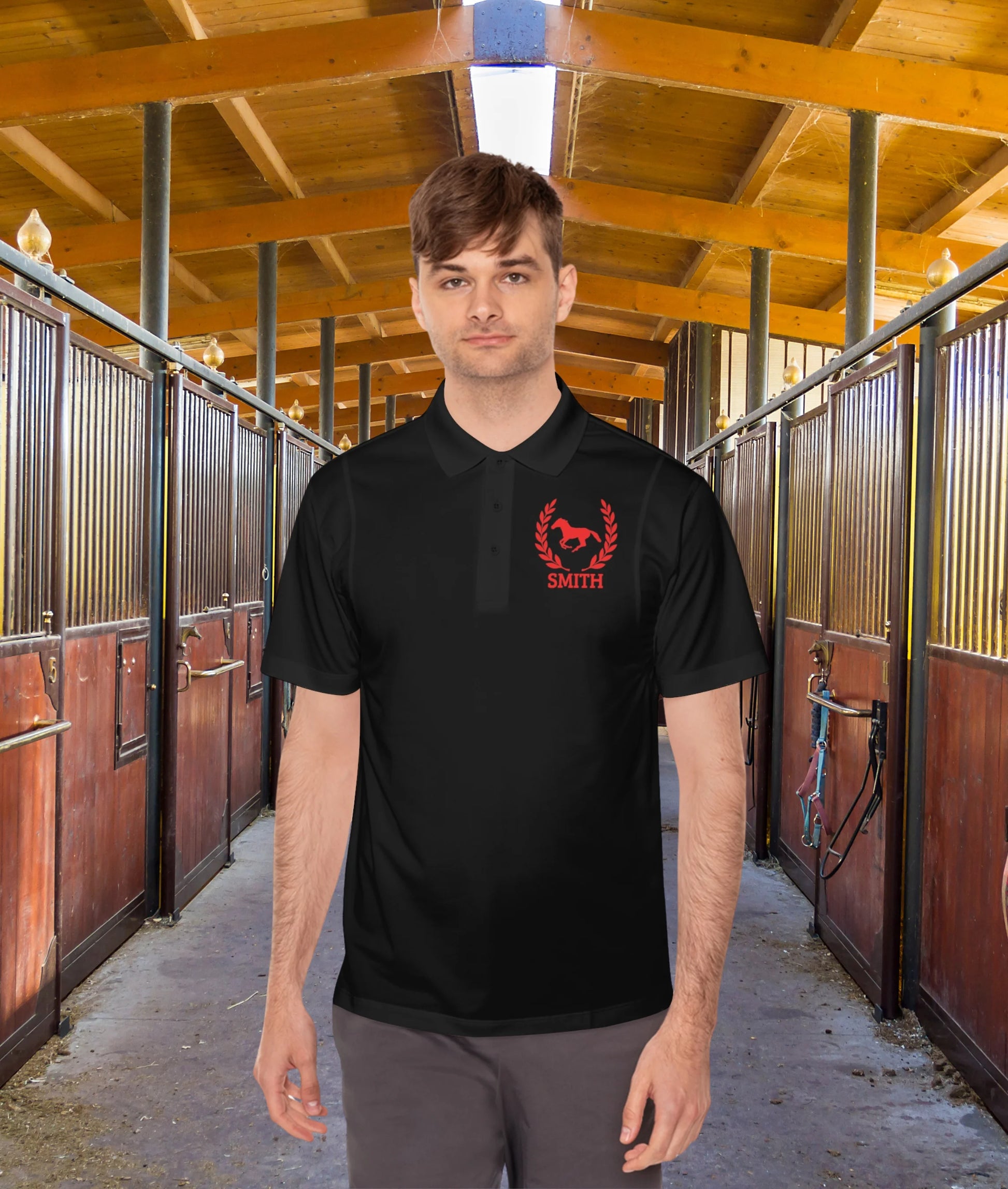black polo shirt red horse Man wearing a black polo shirt with a red logo in a stable setting