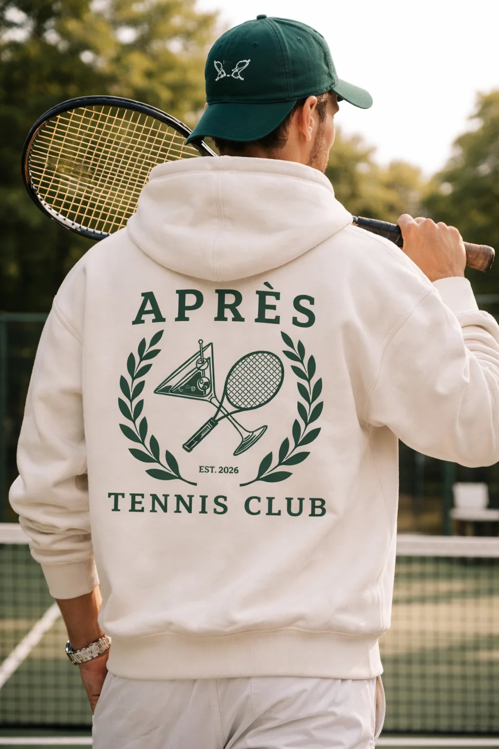 Tennis Hoodie Person wearing a hoodie with 'Apres Tennis Club' design on a tennis court