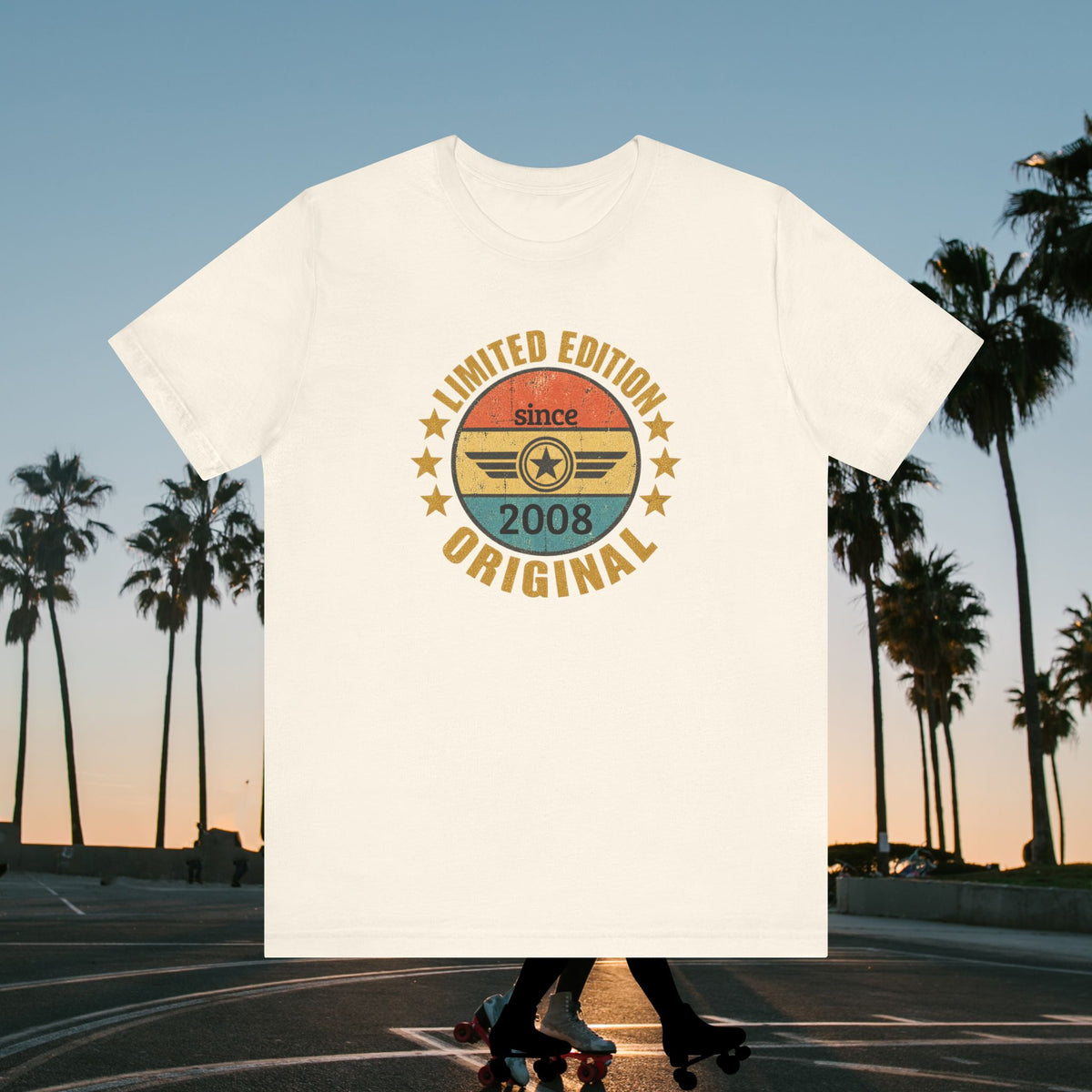 custom year birthday t shirt An off-white short-sleeve t-shirt with a retro circular graphic on the chest, displayed against a blurred background of a sunset street scene with palm trees and a skateboarder.