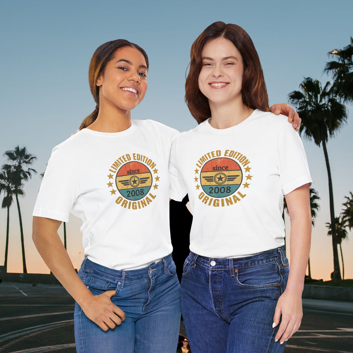 custom year birthday t shirt Two women standing outdoors at sunset wearing matching white graphic T-shirts with a retro circular design in yellow, orange, and teal, paired with blue jeans.