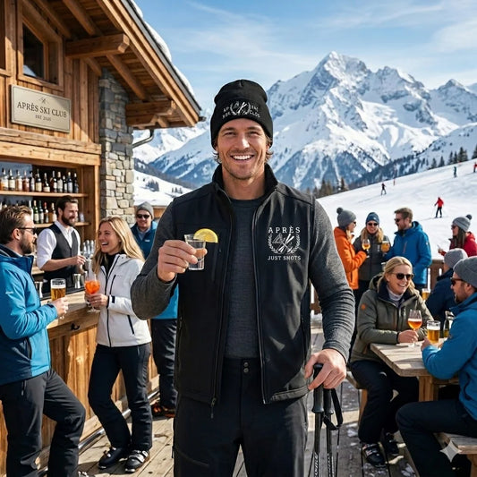 "Men's black softshell skiing vest with integrated technical layering system and white embroidered 'Après Just Shots' crest. Port Authority base."