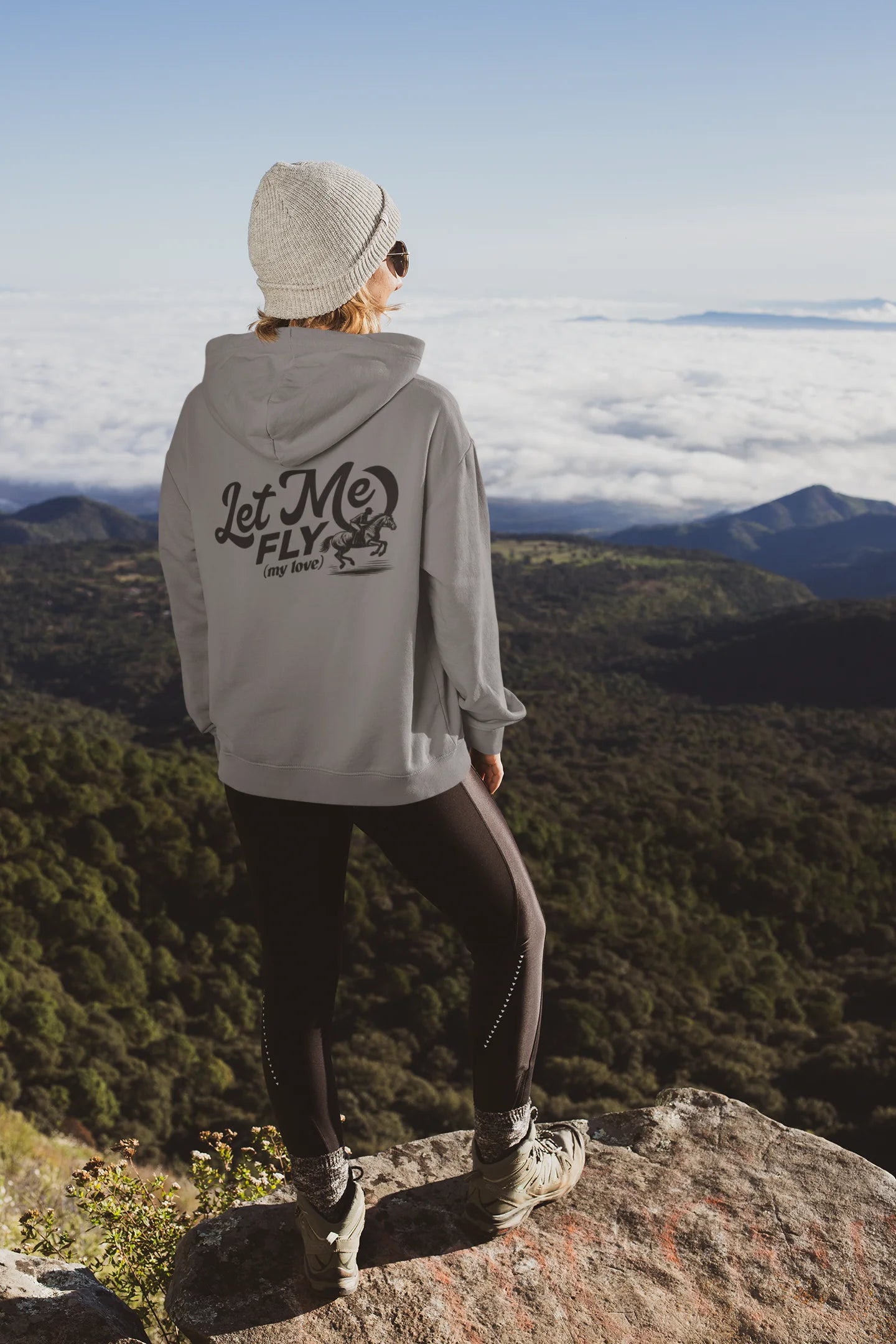 Barn to street Person wearing a hoodie with 'Let Me Fly' text on a mountain top