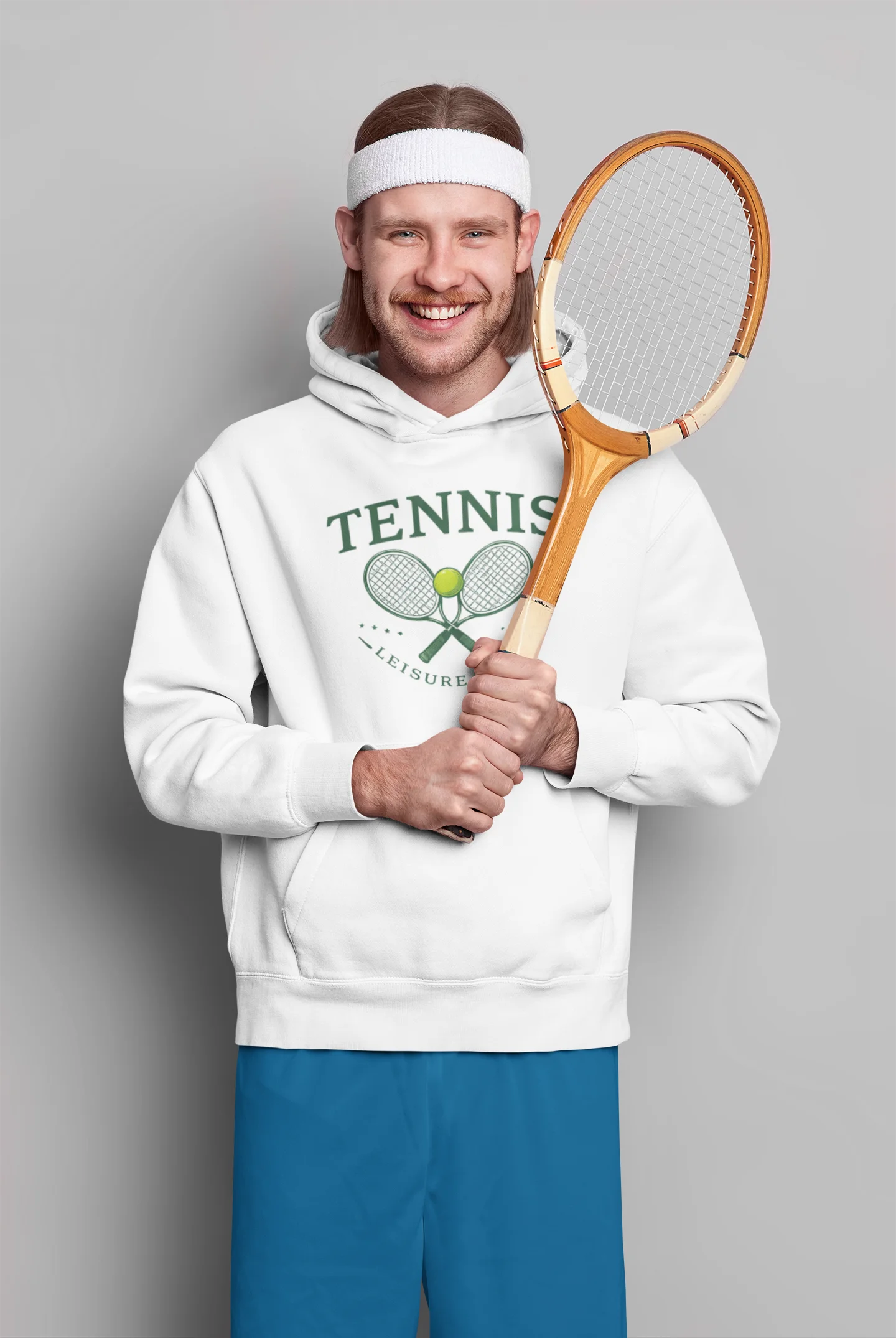 Man wearing a white hoodie with 'Tennis' text and holding a wooden tennis racket against a gray background