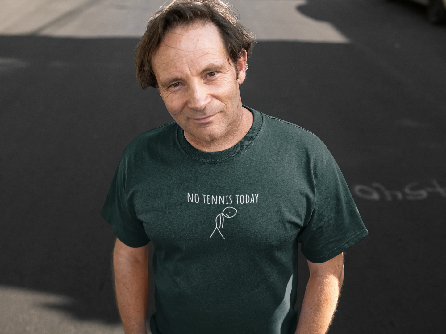 Man wearing a green t-shirt with 'No Tennis Today' text on a dark background