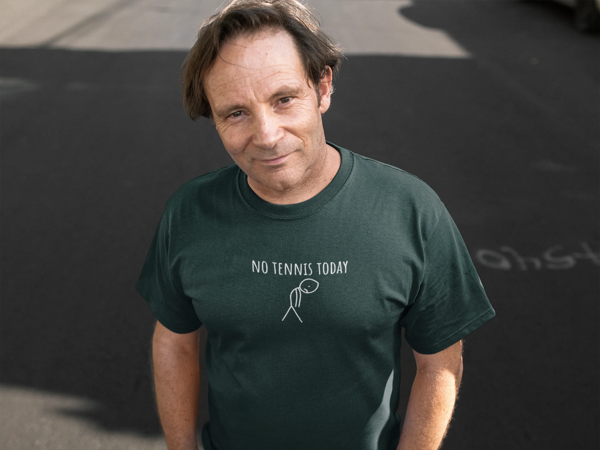 Man wearing a green t-shirt with 'No Tennis Today' text on a dark background