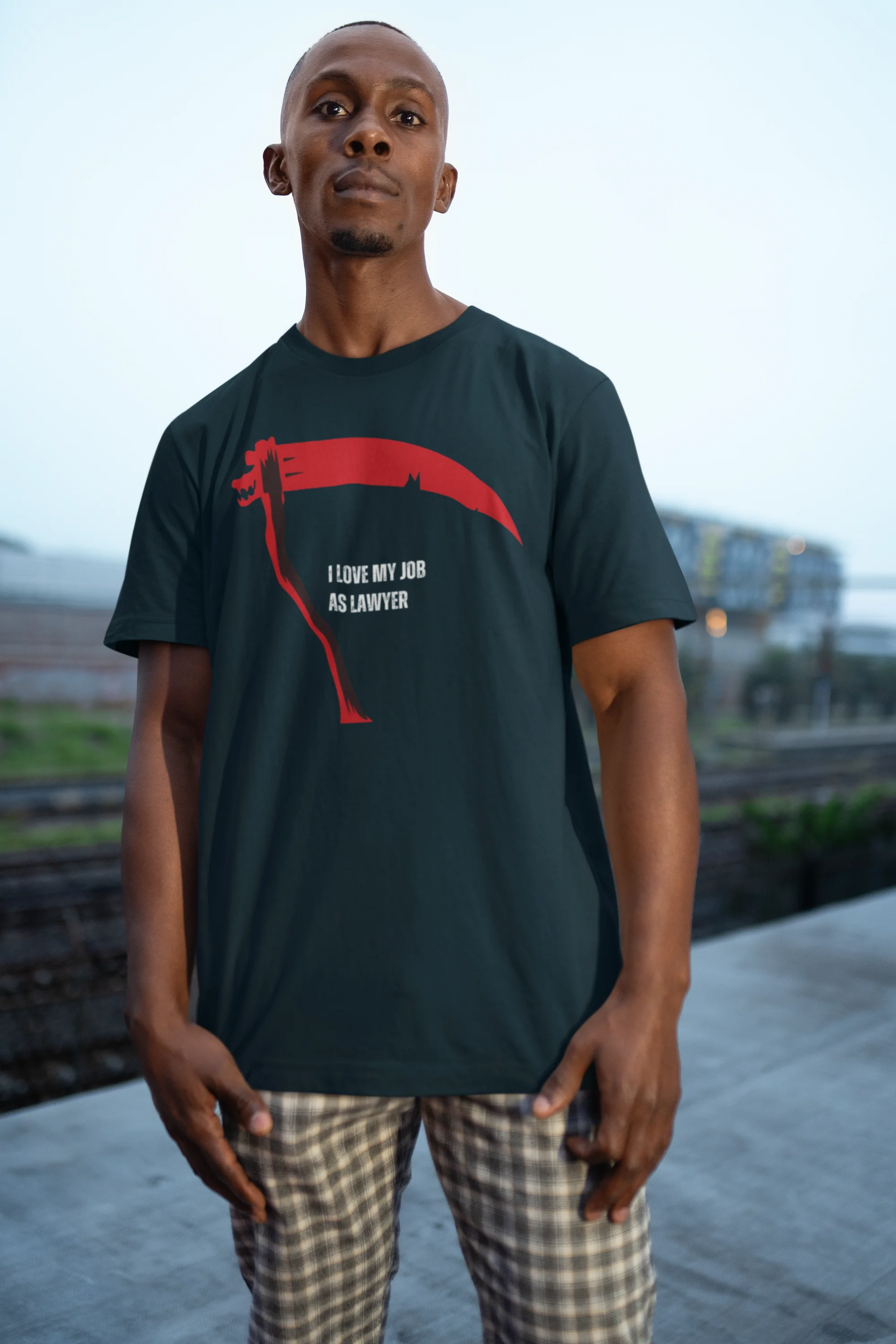 Man wearing a black t-shirt with a red graphic and text, standing outdoors.