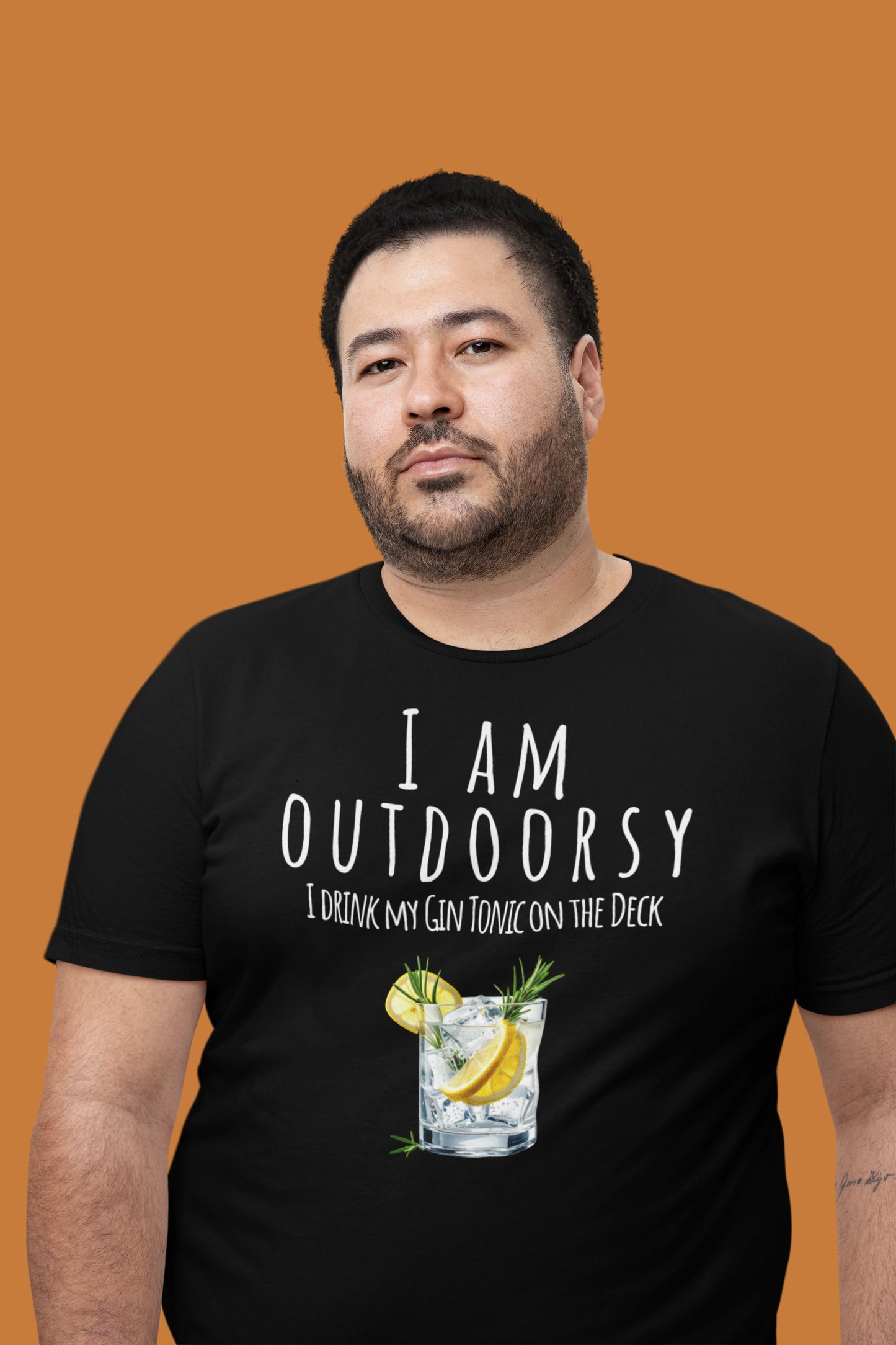 Man wearing a black t-shirt with humorous text and graphic on an orange background