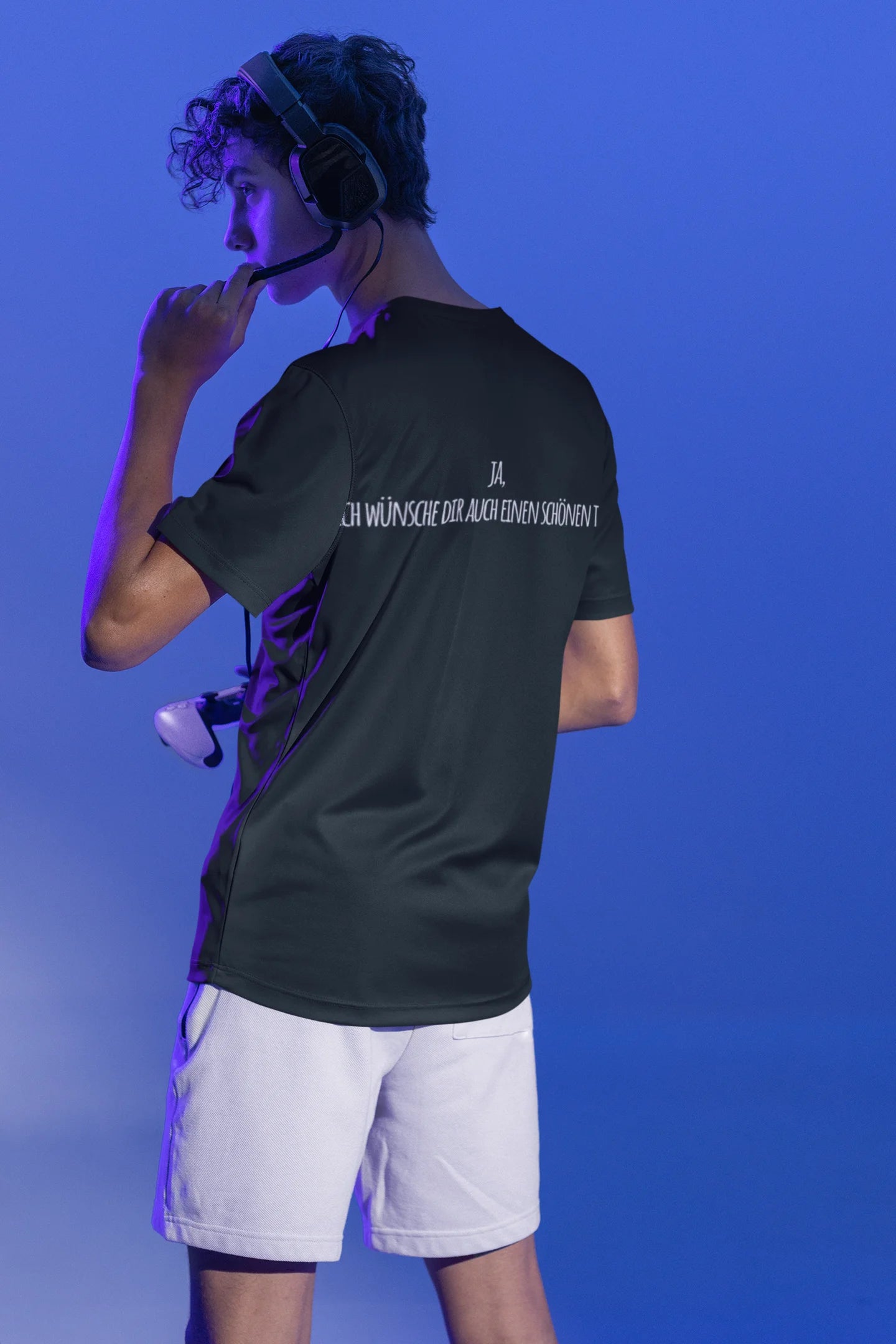 Person wearing a black t-shirt with text on the back against a blue background