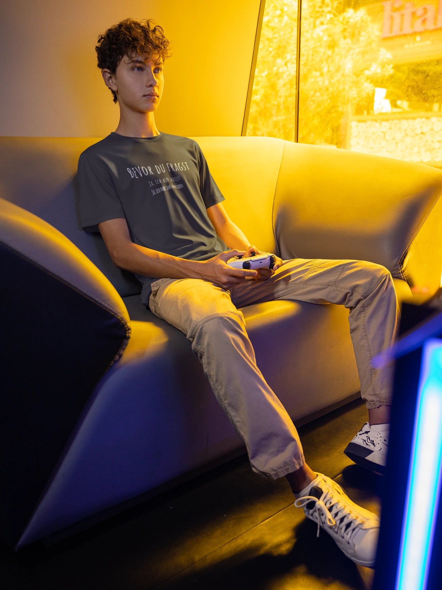 Person sitting on a couch in a dimly lit room with a warm glow.