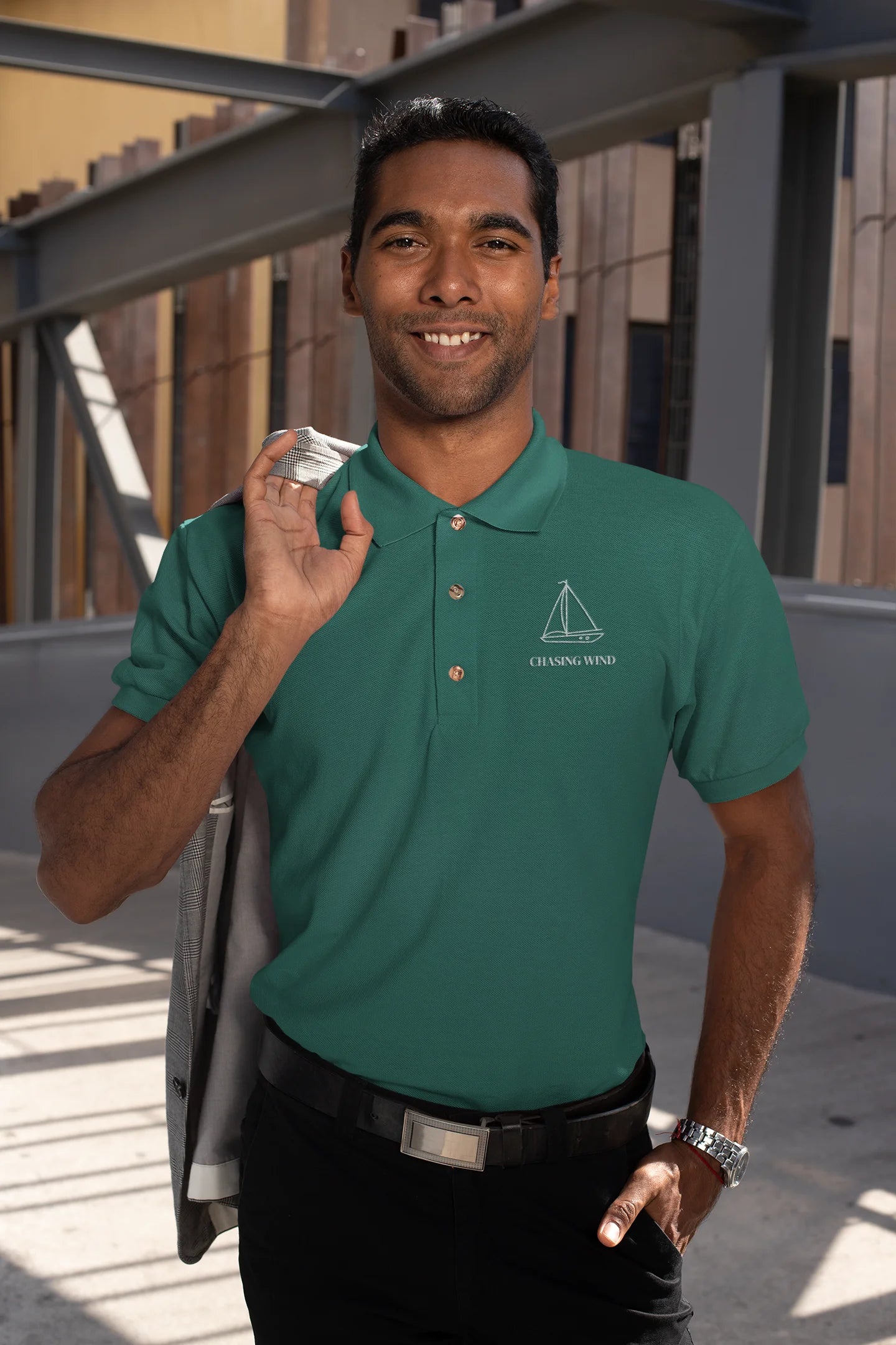 Sailing Polo Shirt Man wearing a green polo shirt with a logo, standing outdoors.