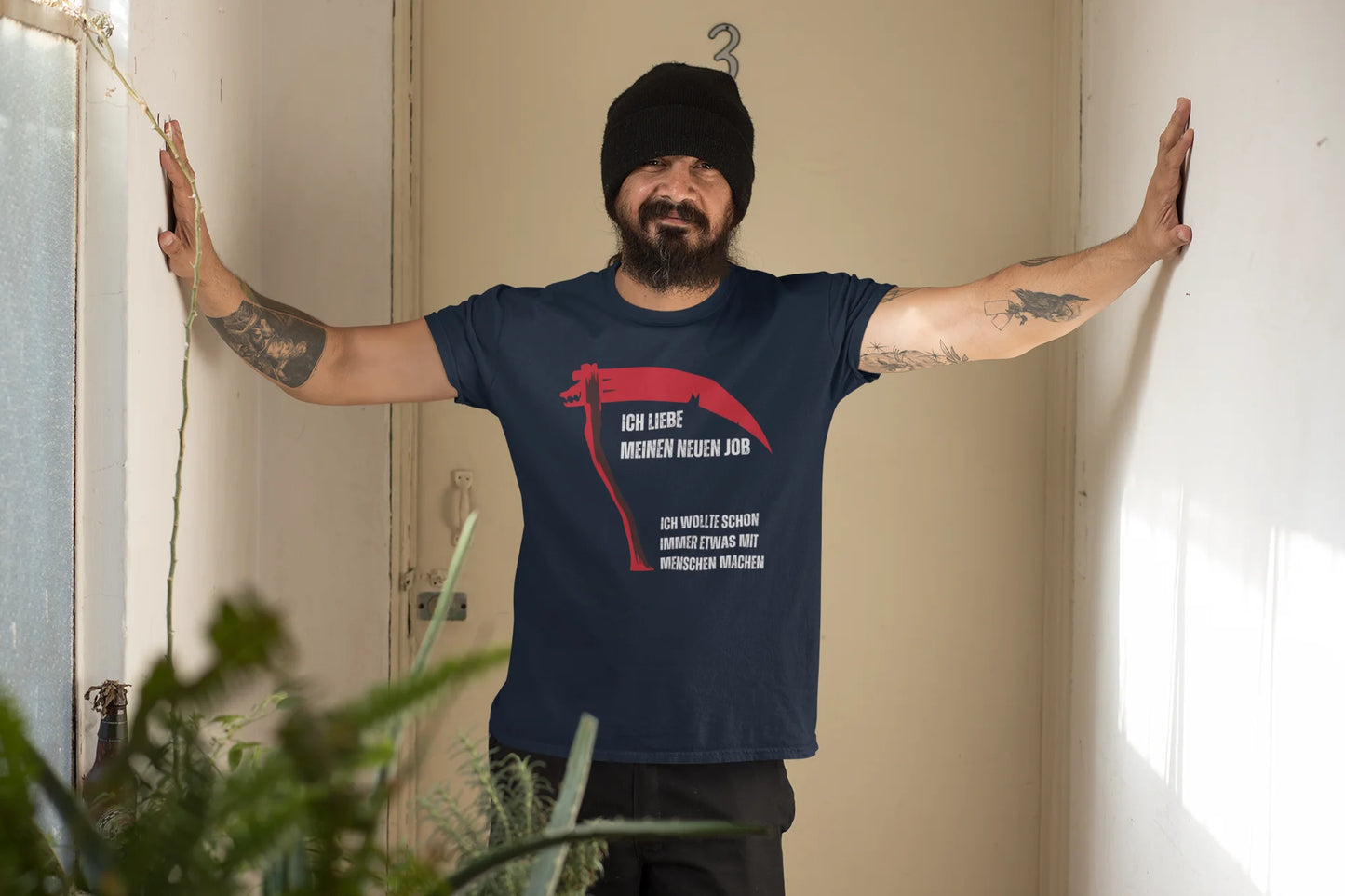 Person wearing a navy blue t-shirt with a red graphic design indoors.