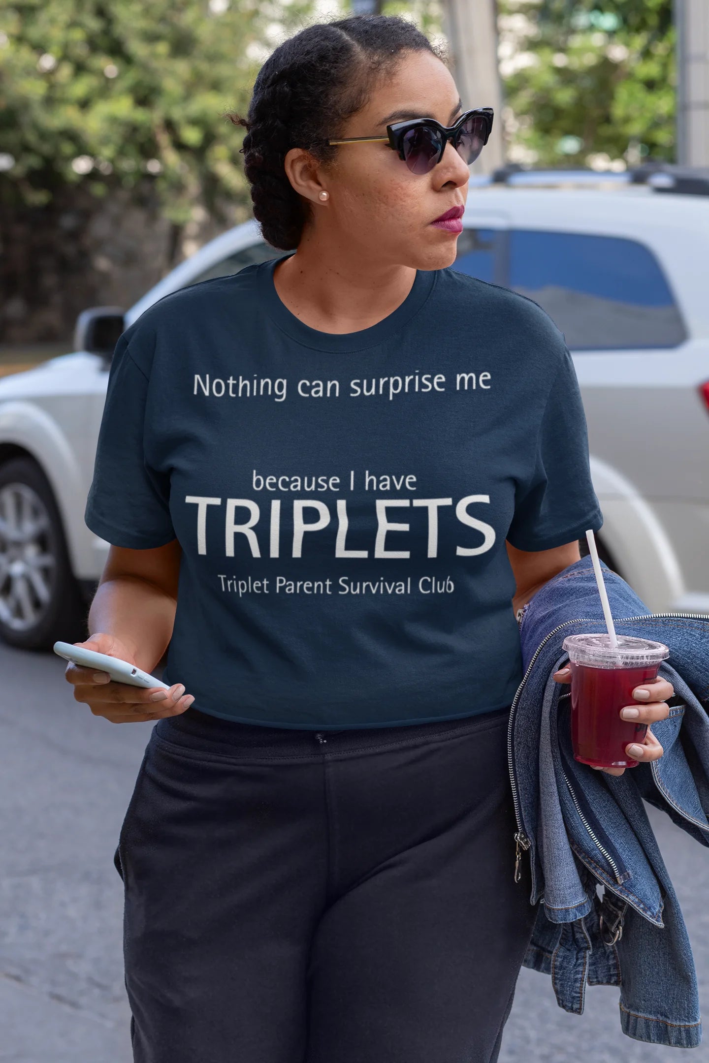 Triplet Gifts Woman wearing a t-shirt with a humorous message about triplets in an urban setting.