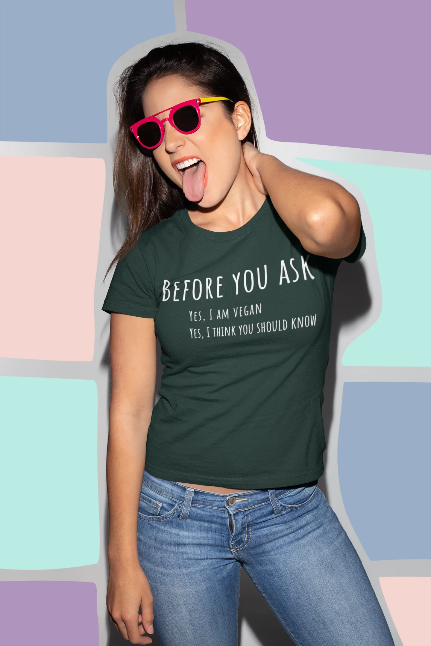 Woman wearing a green t-shirt with a message, standing against a colorful geometric-patterned wall.