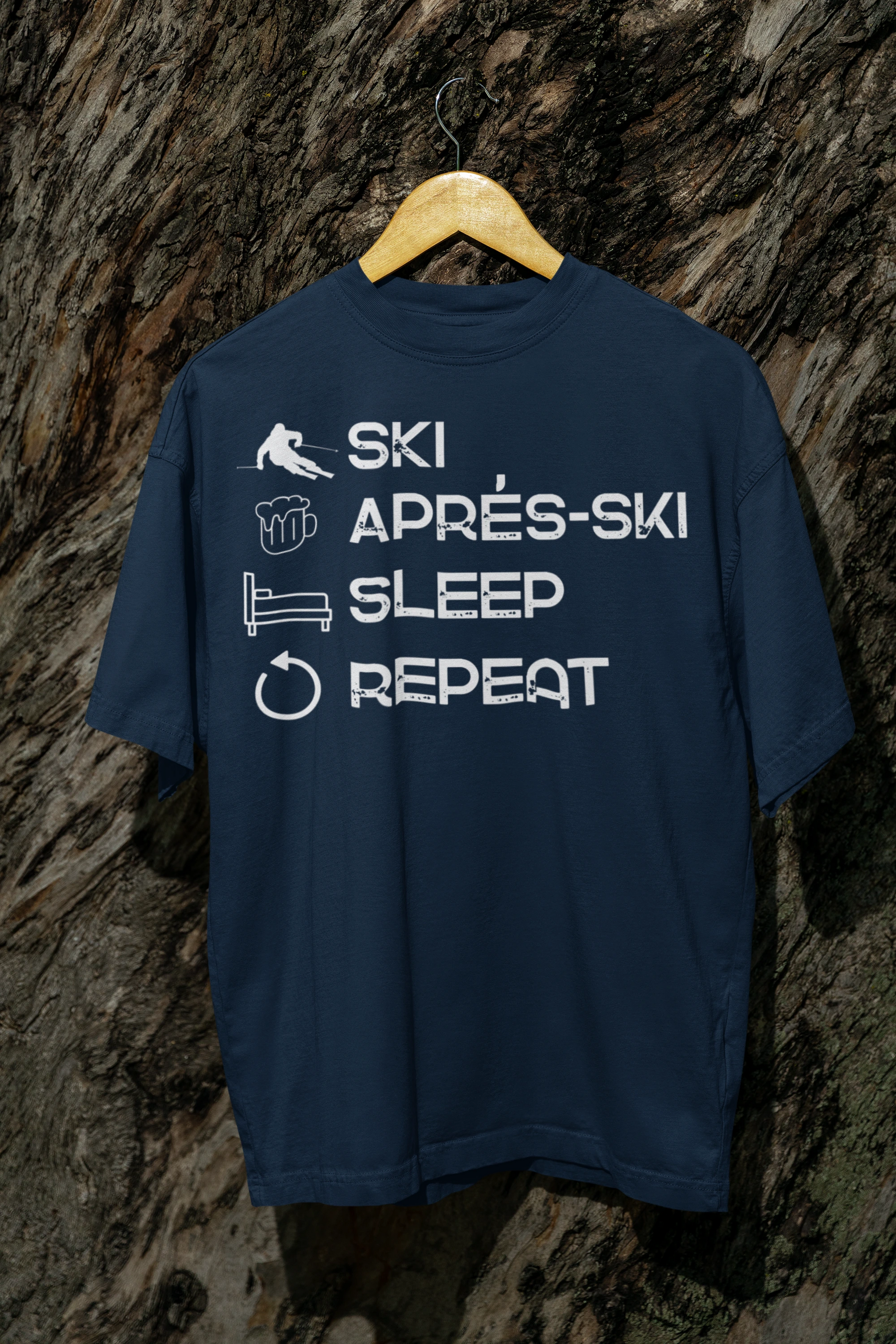 Navy blue t-shirt with white text on a wooden hanger against a stone wall background