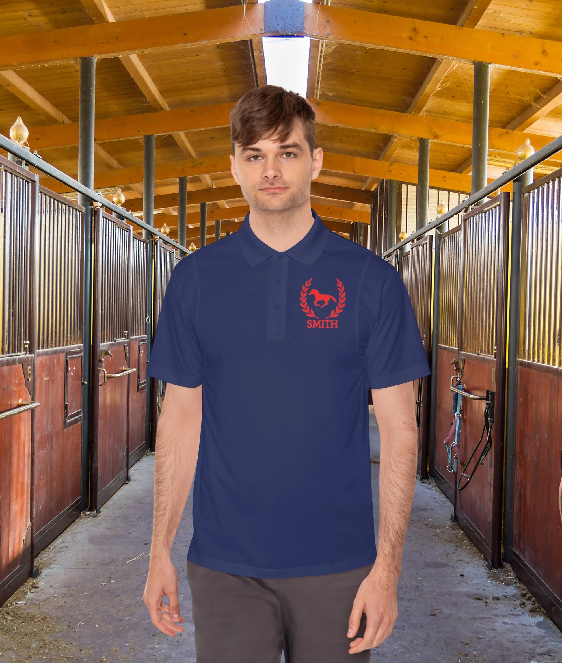 black polo shirt red horse Man wearing a blue polo shirt with a red logo in a stable setting