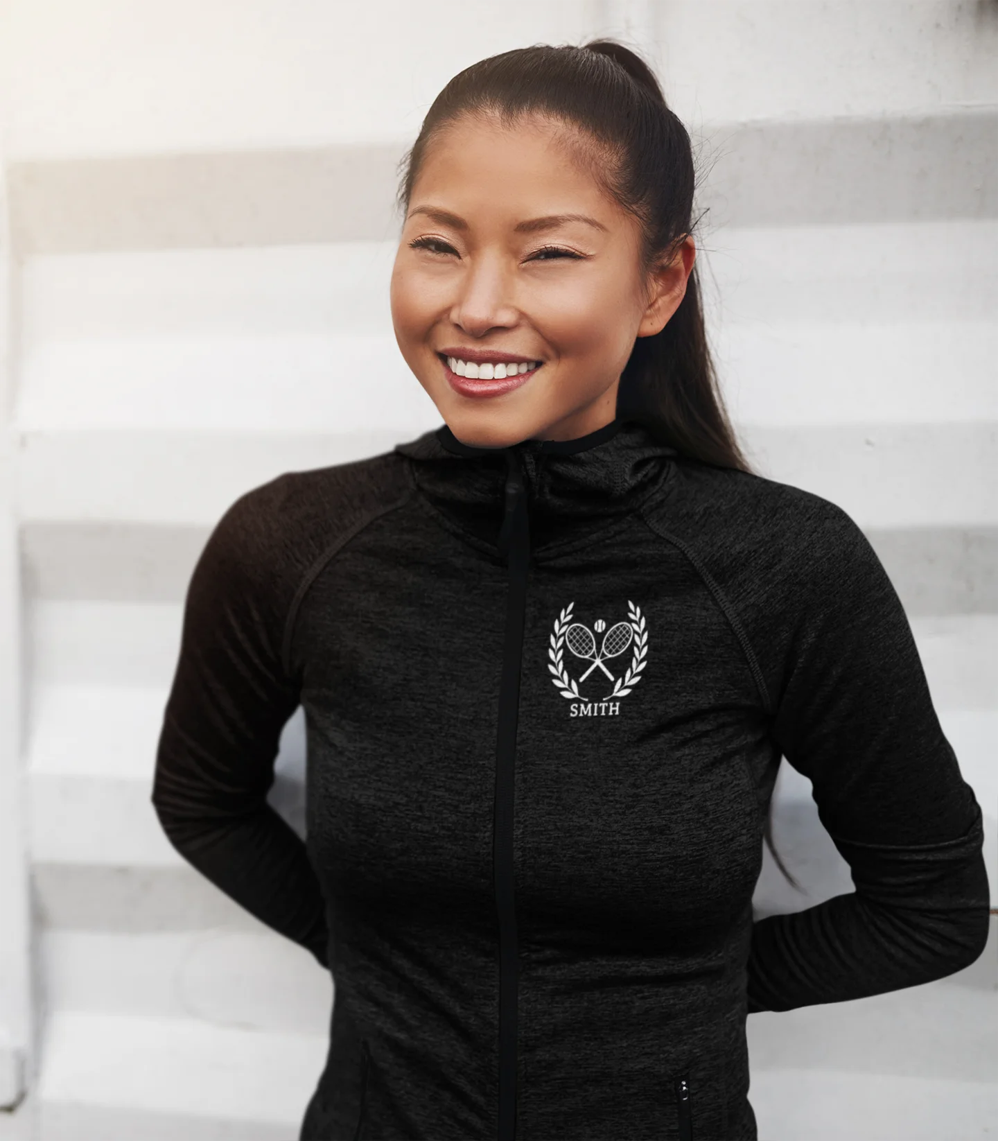 Personalized tennis racket sweater Woman wearing a black athletic jacket with a logo and text on a white background