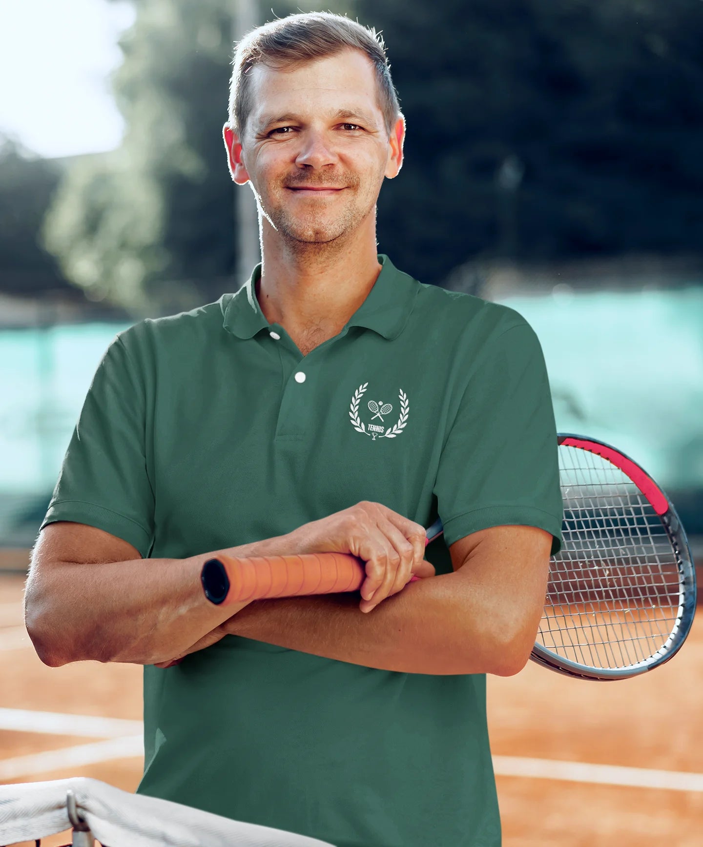 Man in a green polo shirt holding a tennis racket on a tennis court