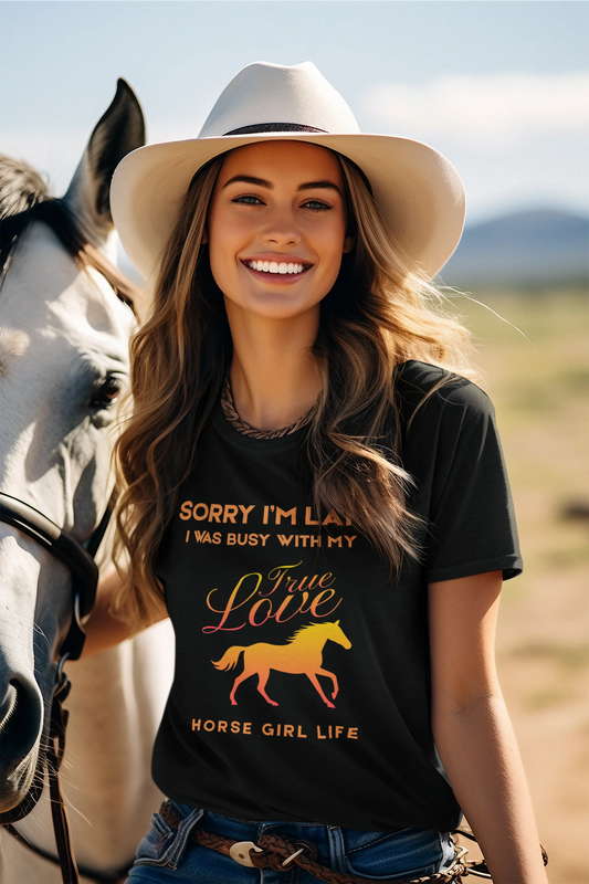Woman wearing a t-shirt with a horse graphic and text, standing next to a horse in an outdoor setting.