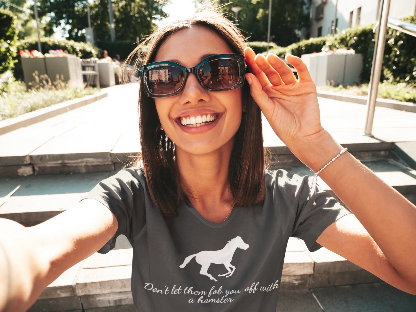 Equestrian Tee Woman wearing sunglasses and a t-shirt with a horse graphic outdoors