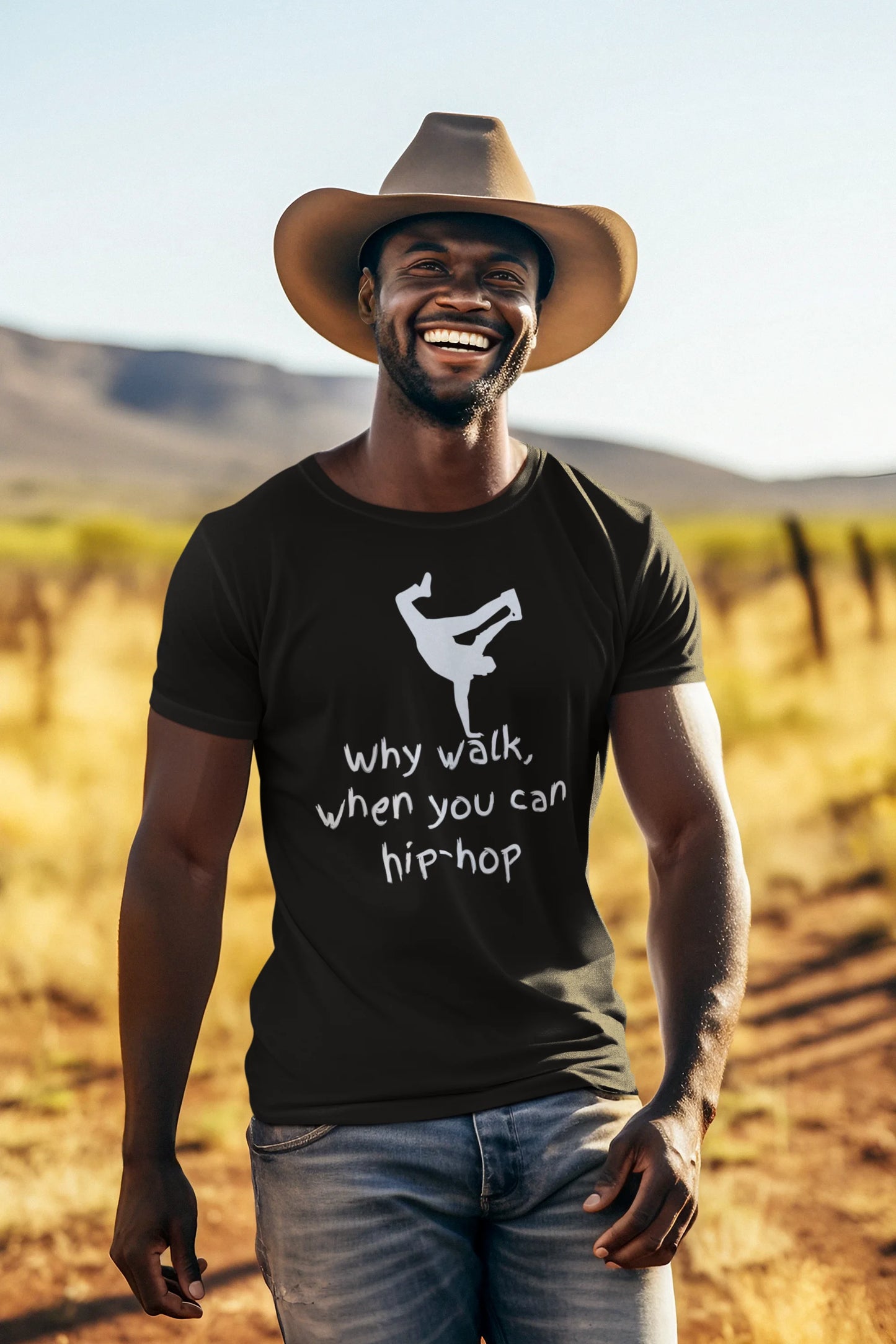 Man wearing a black t-shirt with a graphic and text, standing in a desert landscape.