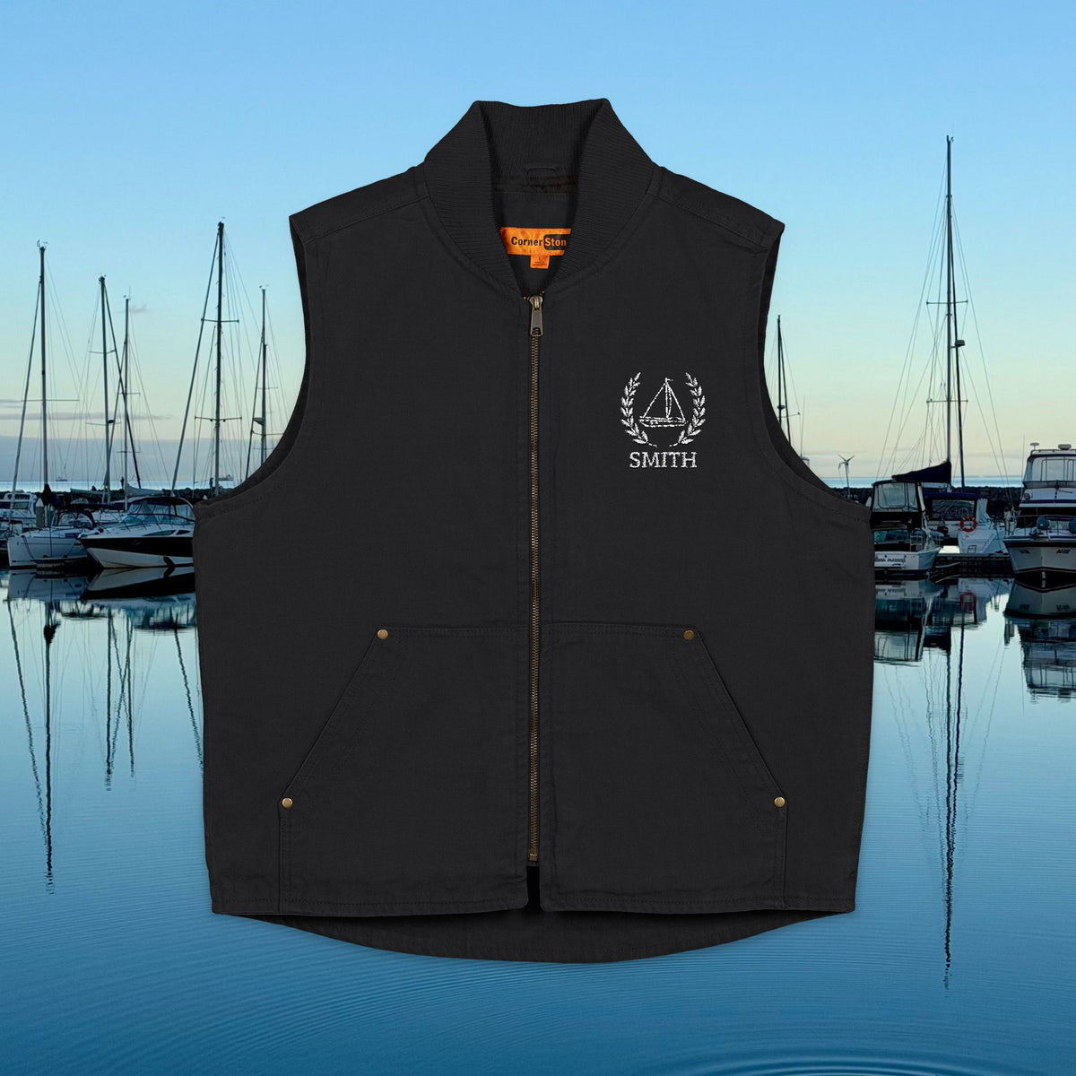 sailing vest A black zip-front vest with a stand collar, front pockets, and a white embroidered crest and the word 'SMITH' on the left chest, shown against a marina background at dusk.