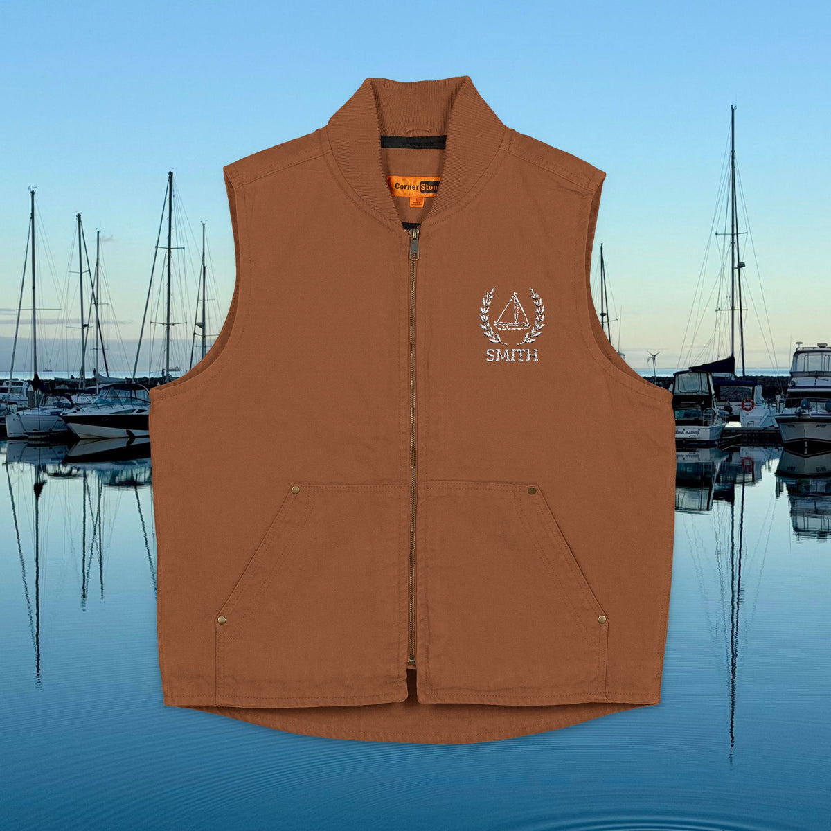 sailing vest A sleeveless zip-front vest in a warm rust brown color, featuring a white embroidered 'SMITH' logo with a sailboat graphic on the left chest. The vest is displayed against a digital background of a marina at sunset.