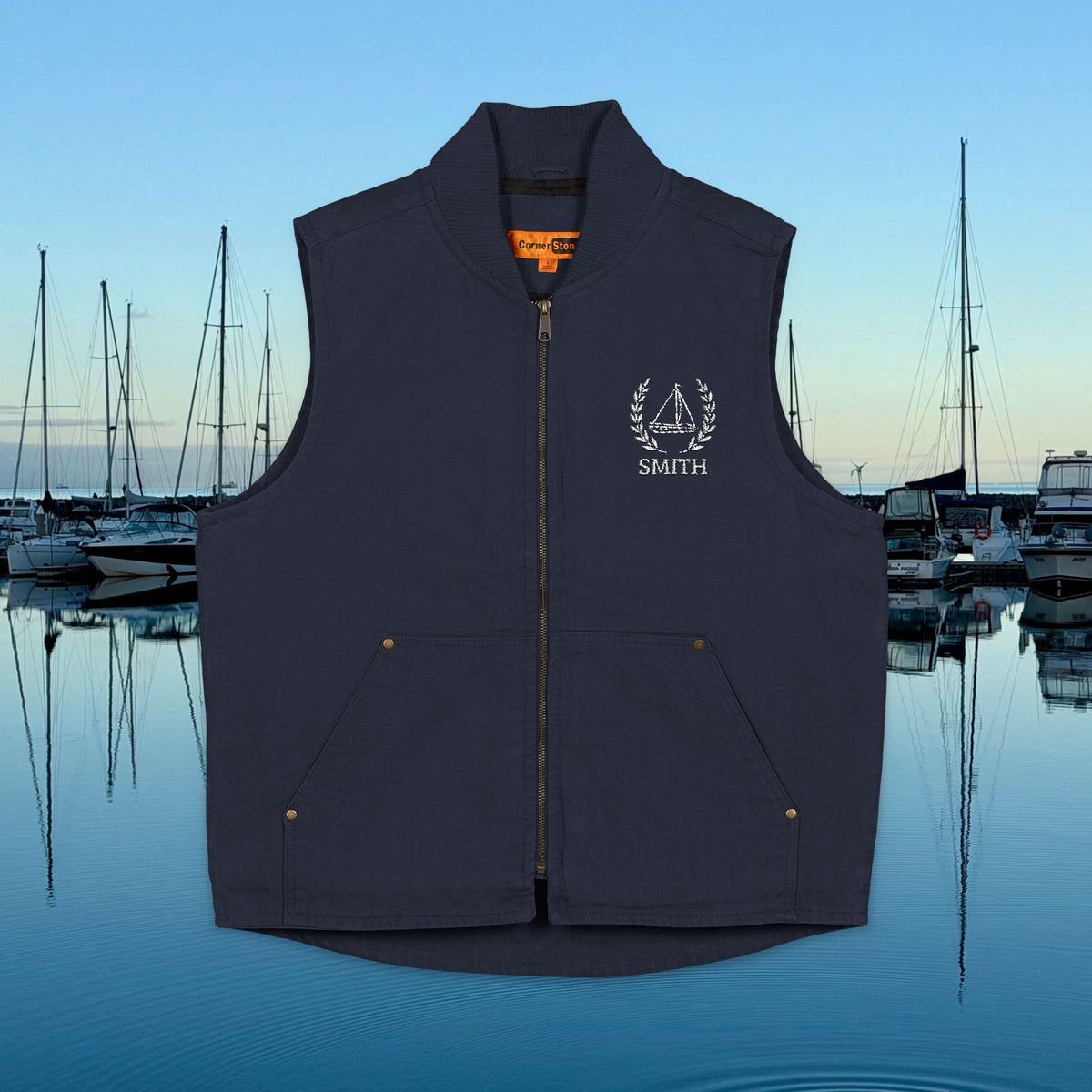 sailing vest A black zip-front vest with a stand collar, front pockets, and a white embroidered crest and the word 'SMITH' on the left chest, shown against a marina background at dusk.