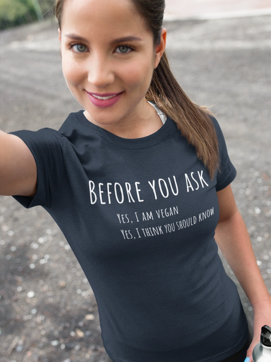 Woman wearing a black t-shirt with a vegan message outdoors.