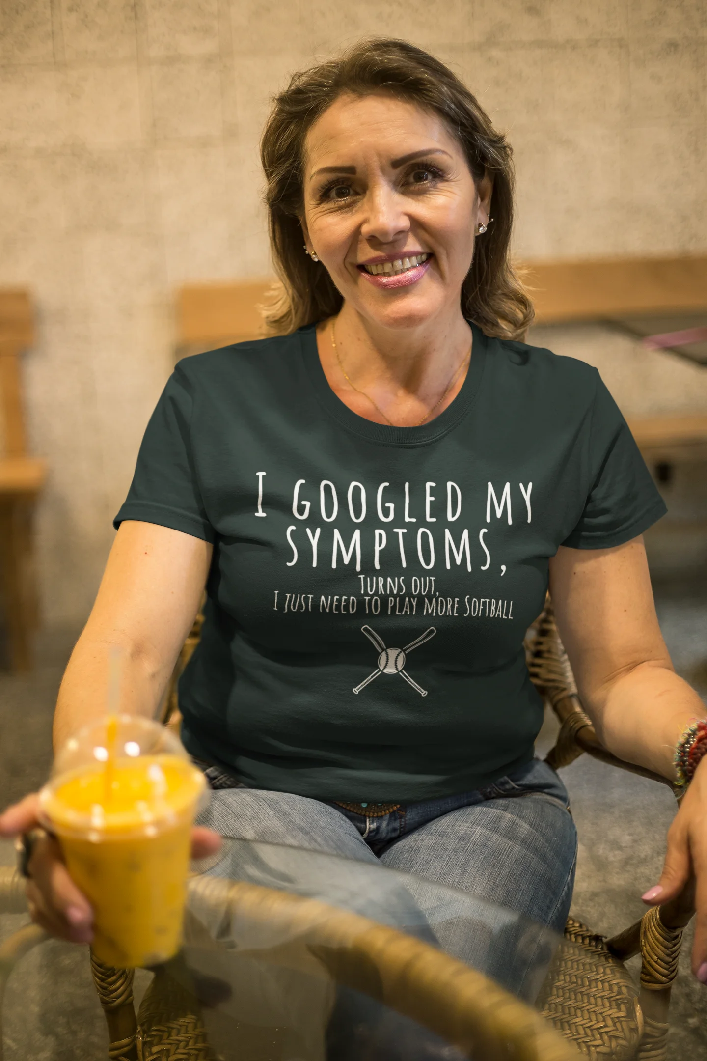 Woman wearing a t-shirt with humorous text, holding a drink.