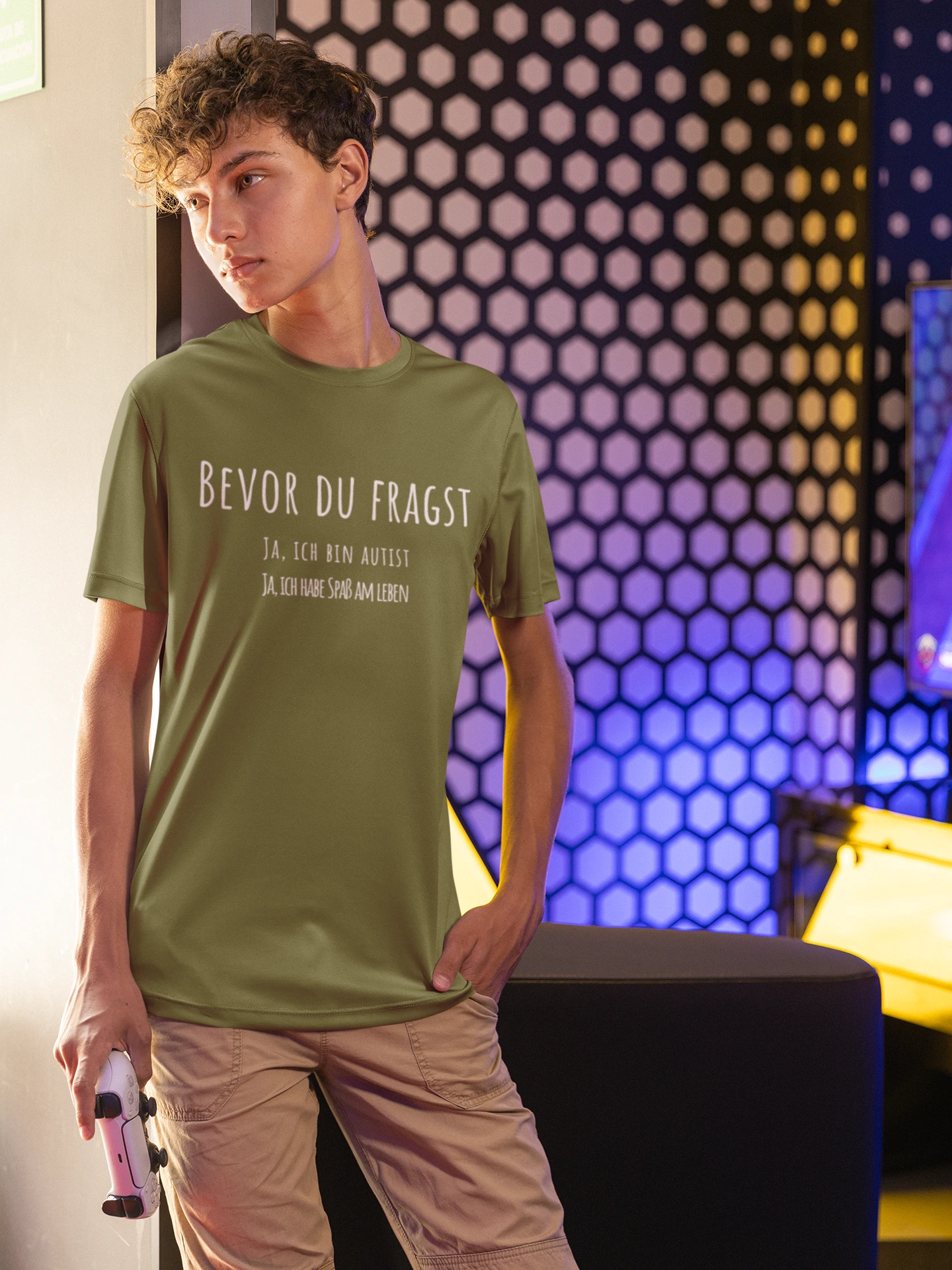 Person wearing a green t-shirt with text, standing in a room with colorful lighting.