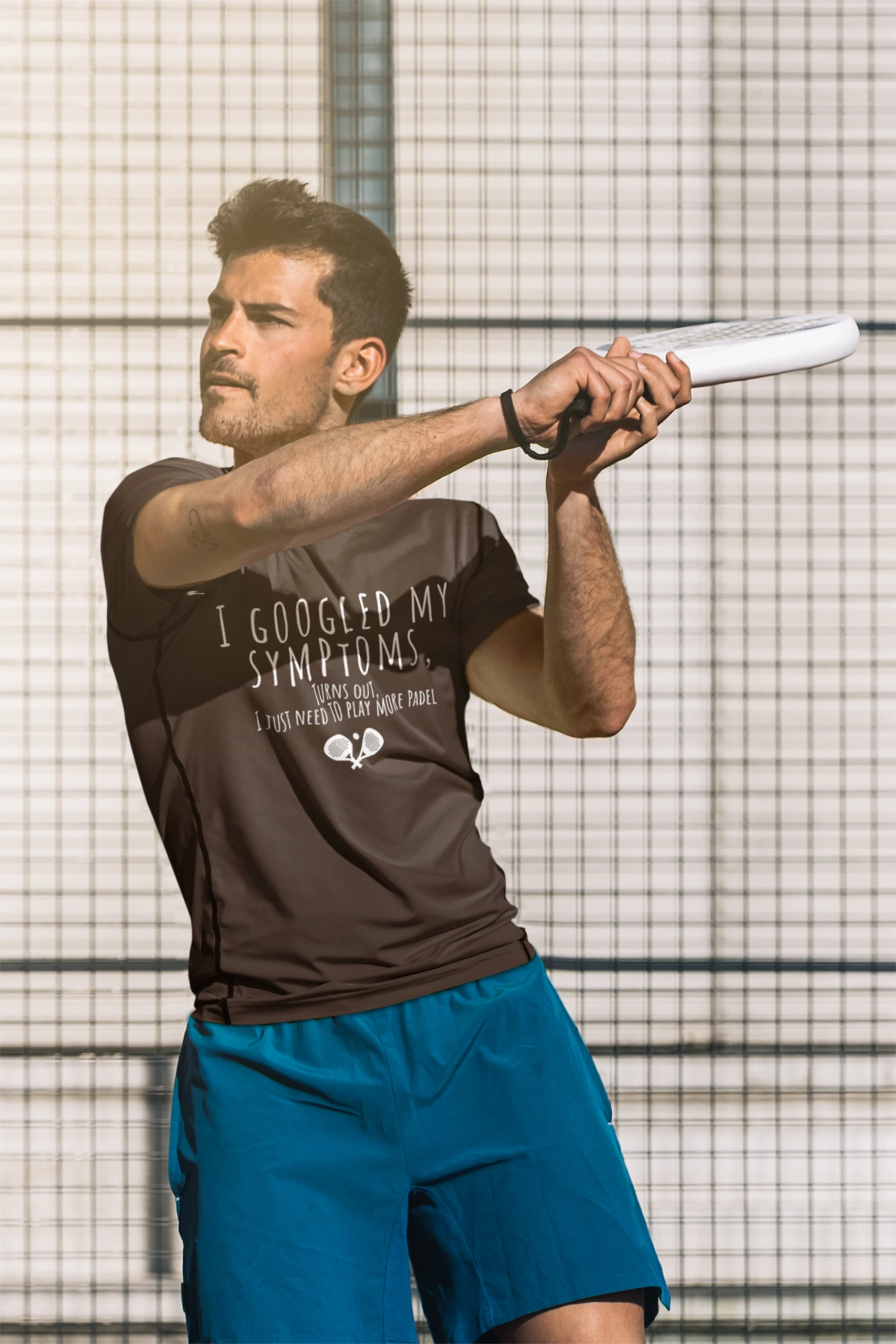Man holding a tennis racket with a branded shirt and blue shorts against a grid background
