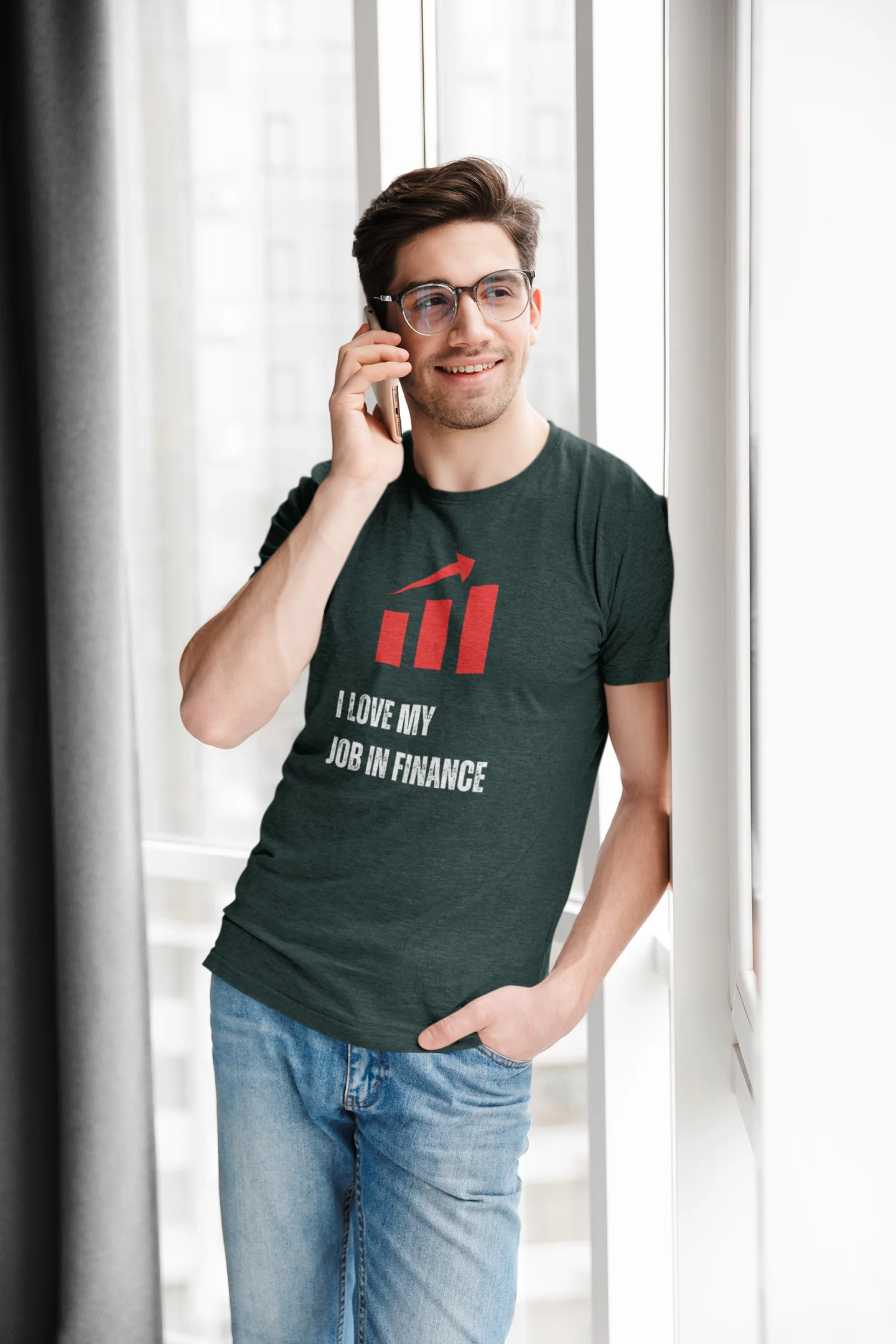 Finance Manager Shirt Man wearing a t-shirt with 'I love my job in finance' text, talking on a phone indoors.