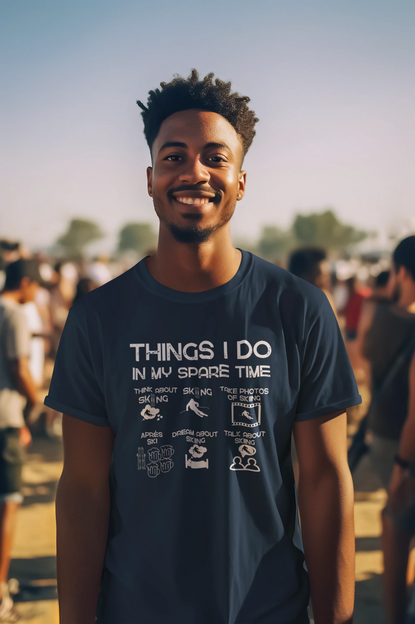 Man wearing a t-shirt with text and graphics, standing outdoors with a crowd in the background.