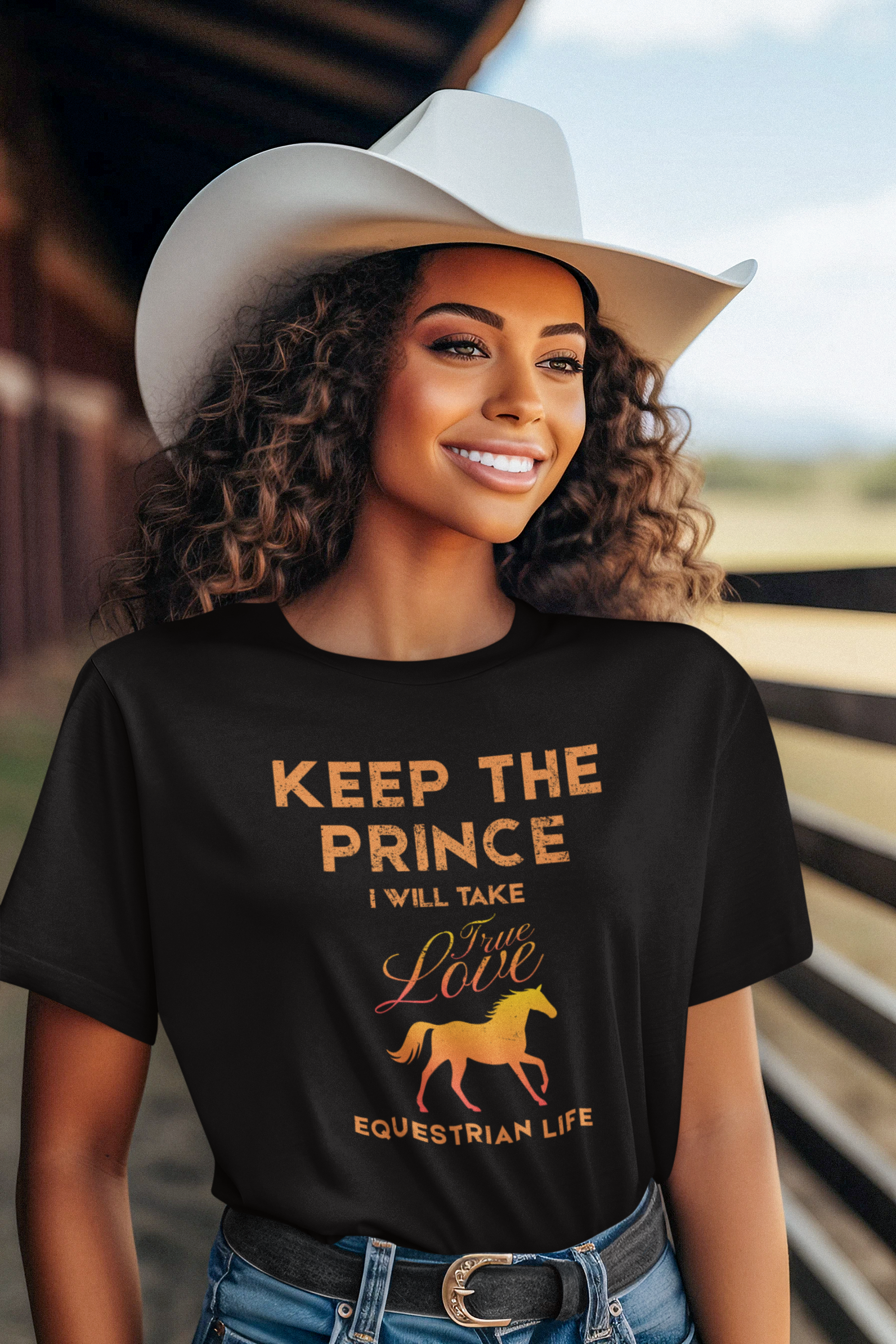 Woman wearing a black t-shirt with equestrian-themed text and graphics, standing in a barn.