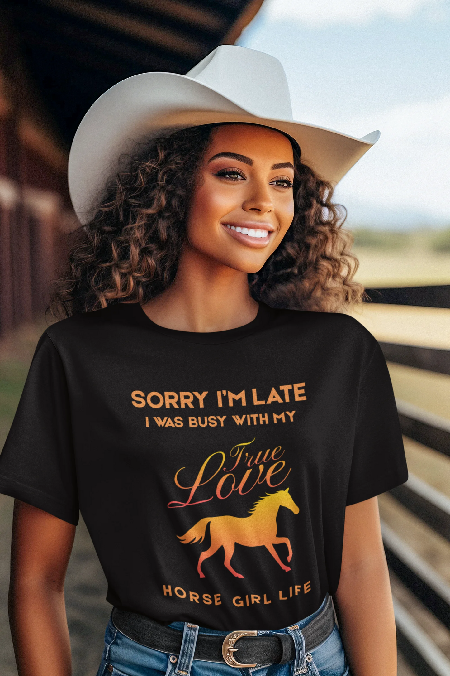 Woman wearing a black t-shirt with a horse graphic and text, standing in a barn.