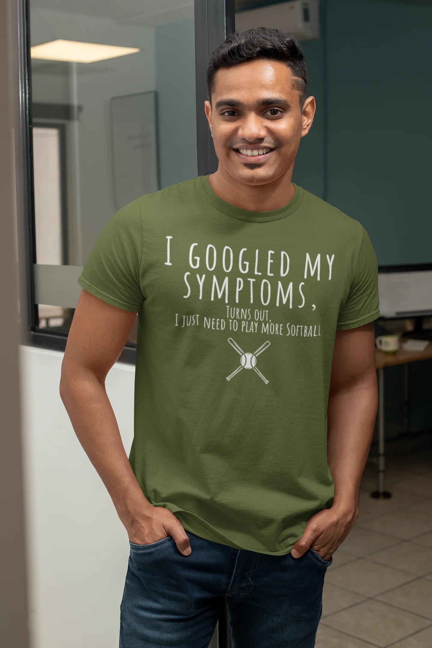 Man wearing a green t-shirt with humorous text in an office setting