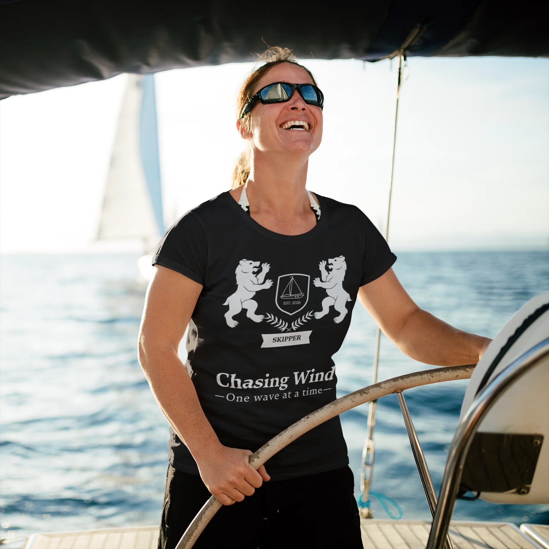 Sailing Boat T Shirt Person on a boat wearing a black t-shirt with a design and text, with water in the background