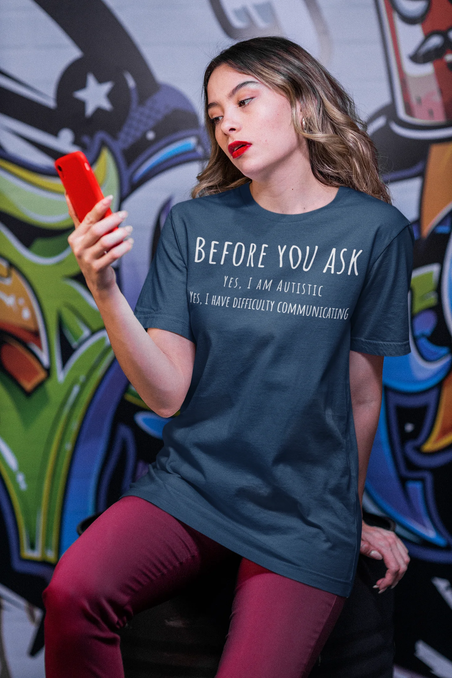Woman wearing a t-shirt with text in front of a colorful graffiti wall